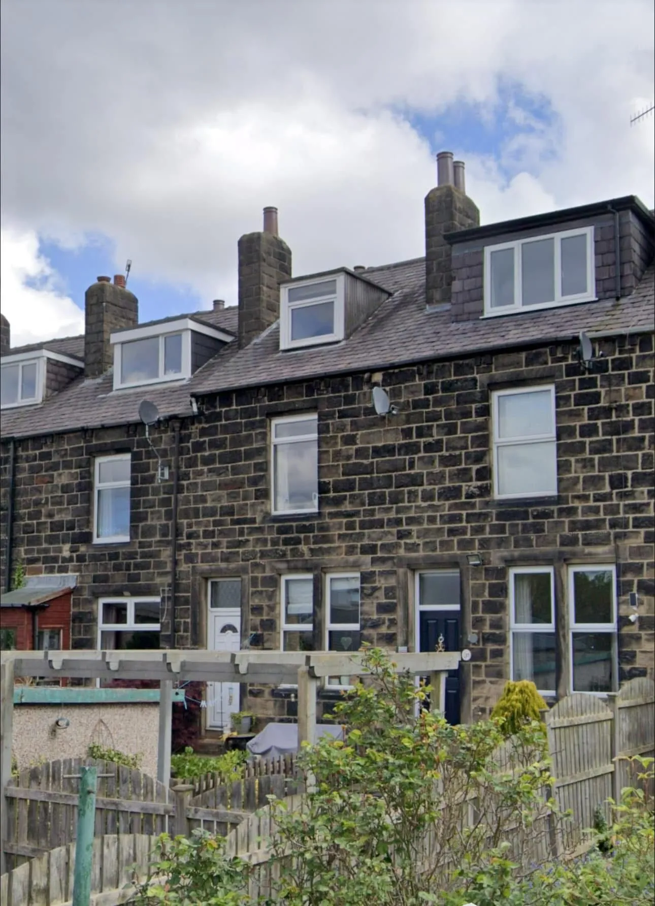 Traditional stone terrace houses with slate roofs and dormer windows in Otley or Leeds, West Yorkshire.