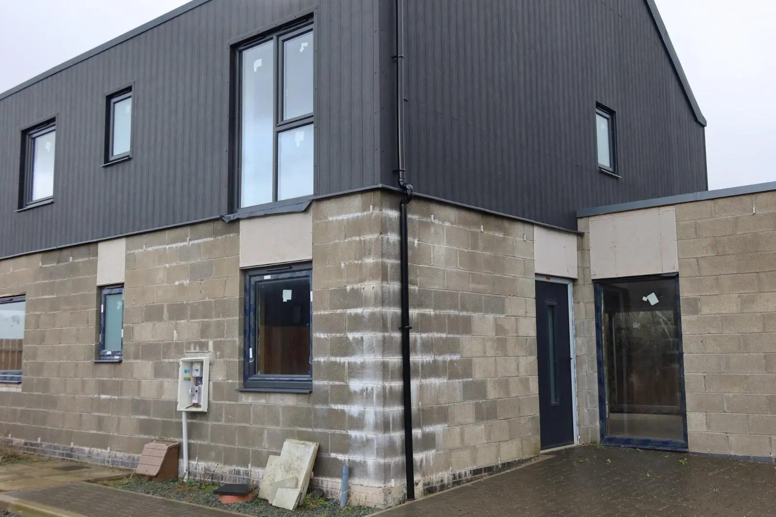 A property with exposed concrete blockwork, prepared for external wall insulation and silicone rendering to improve energy efficiency.