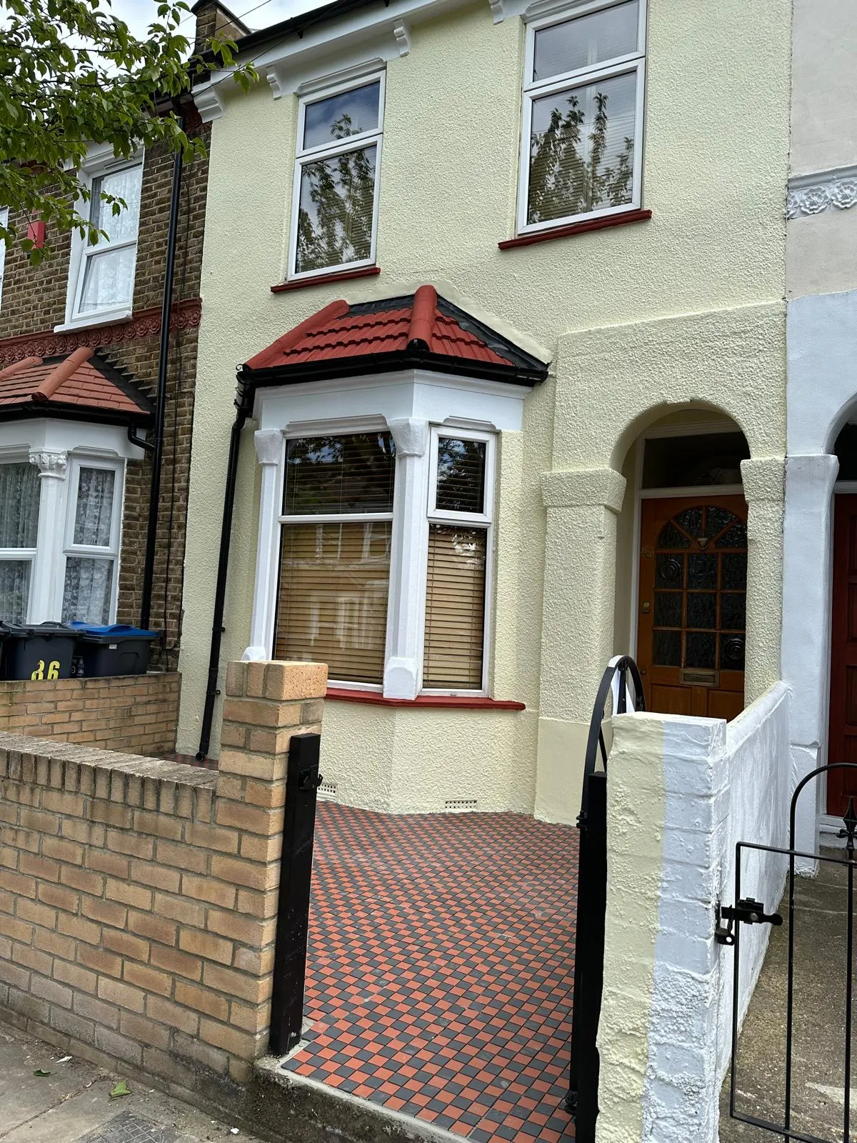 Front of a house with fresh cream paint and a new checkered block paving entrance