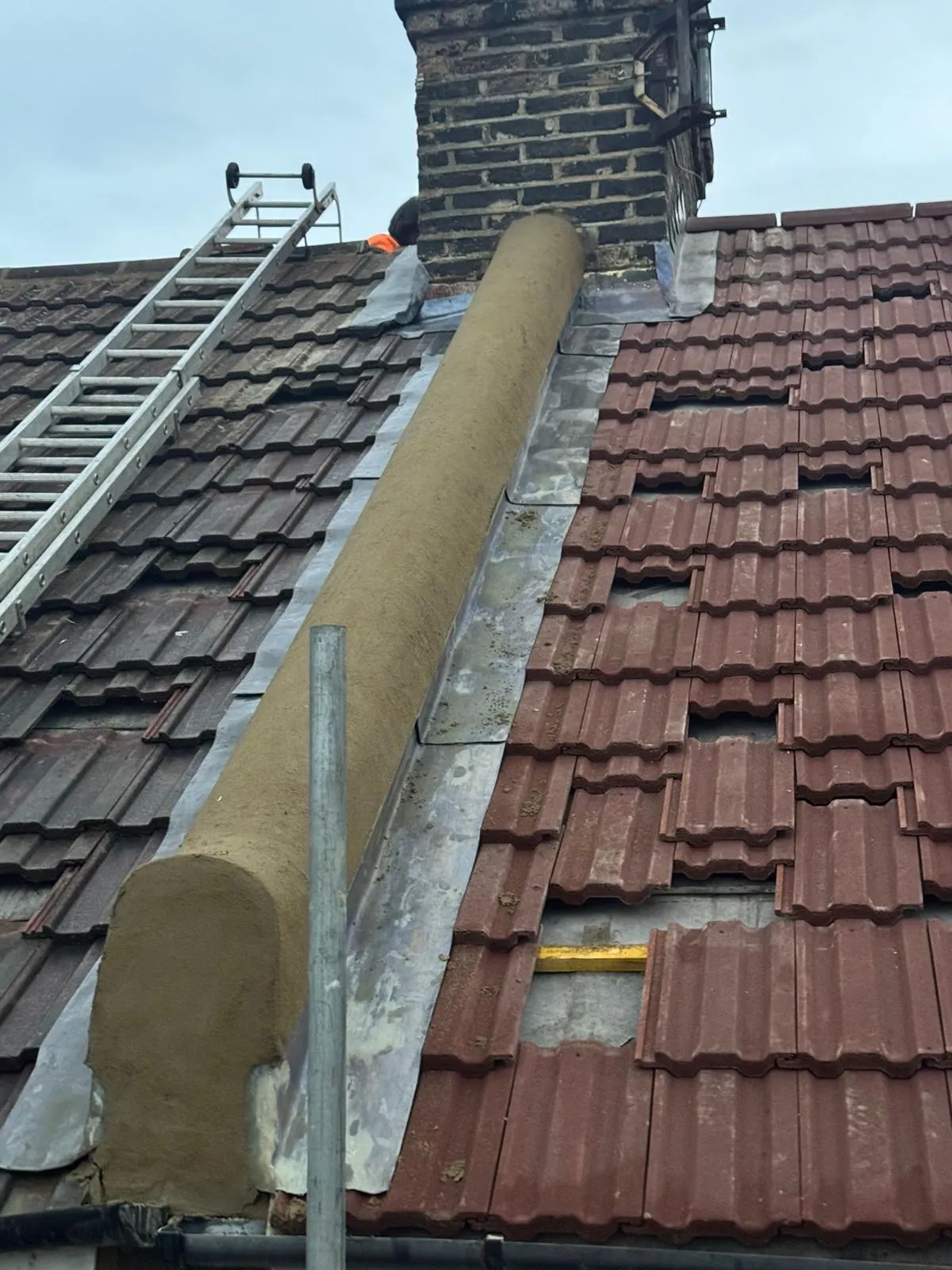 Roof lead flashing and party wall repointing on a pitched tile roof beside a chimney stack
