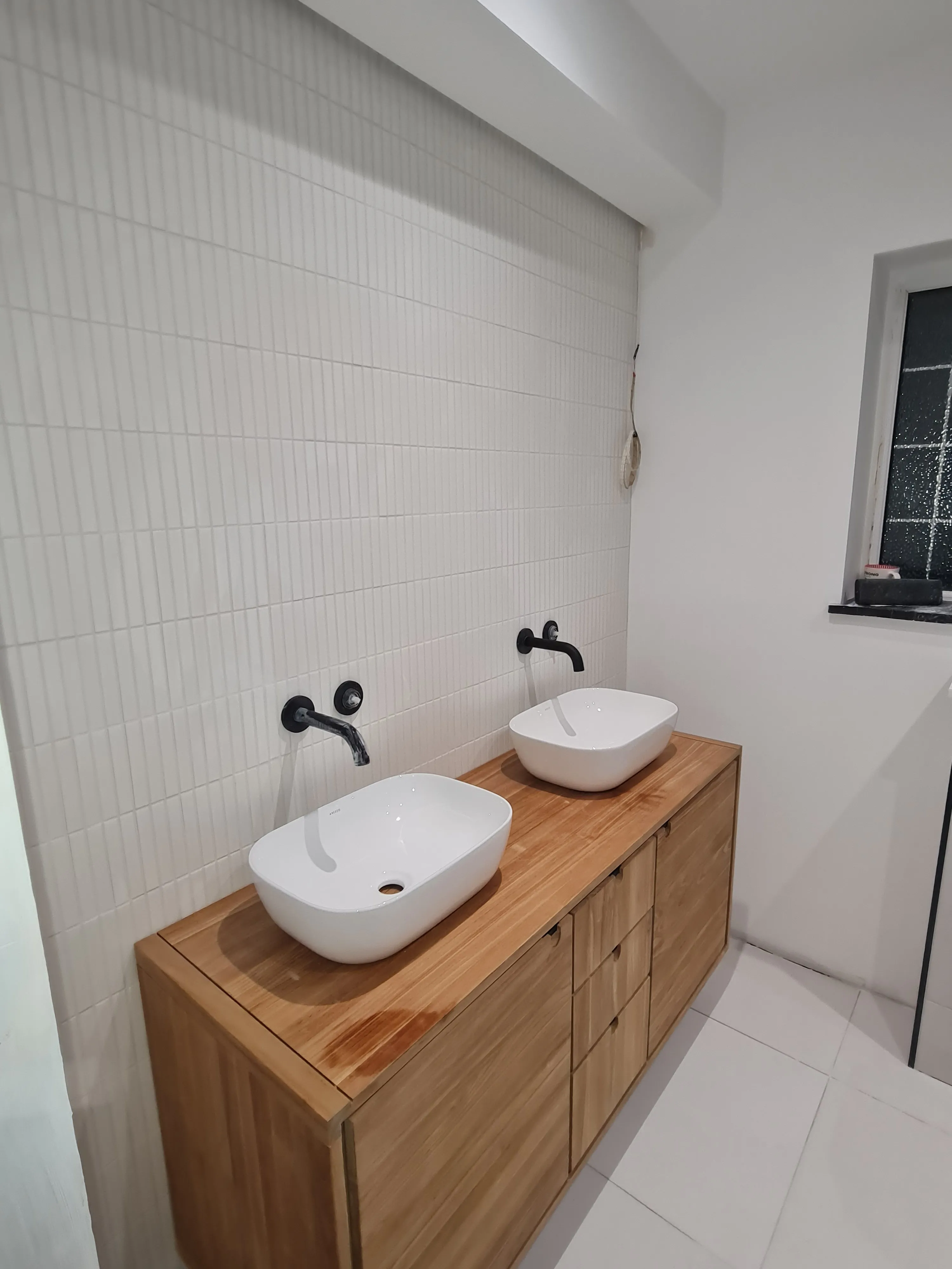 Luxury master bathroom installation in Plymouth featuring a double vanity, white kit-kat tiles, and matte black fixtures by Sands & Vossen.