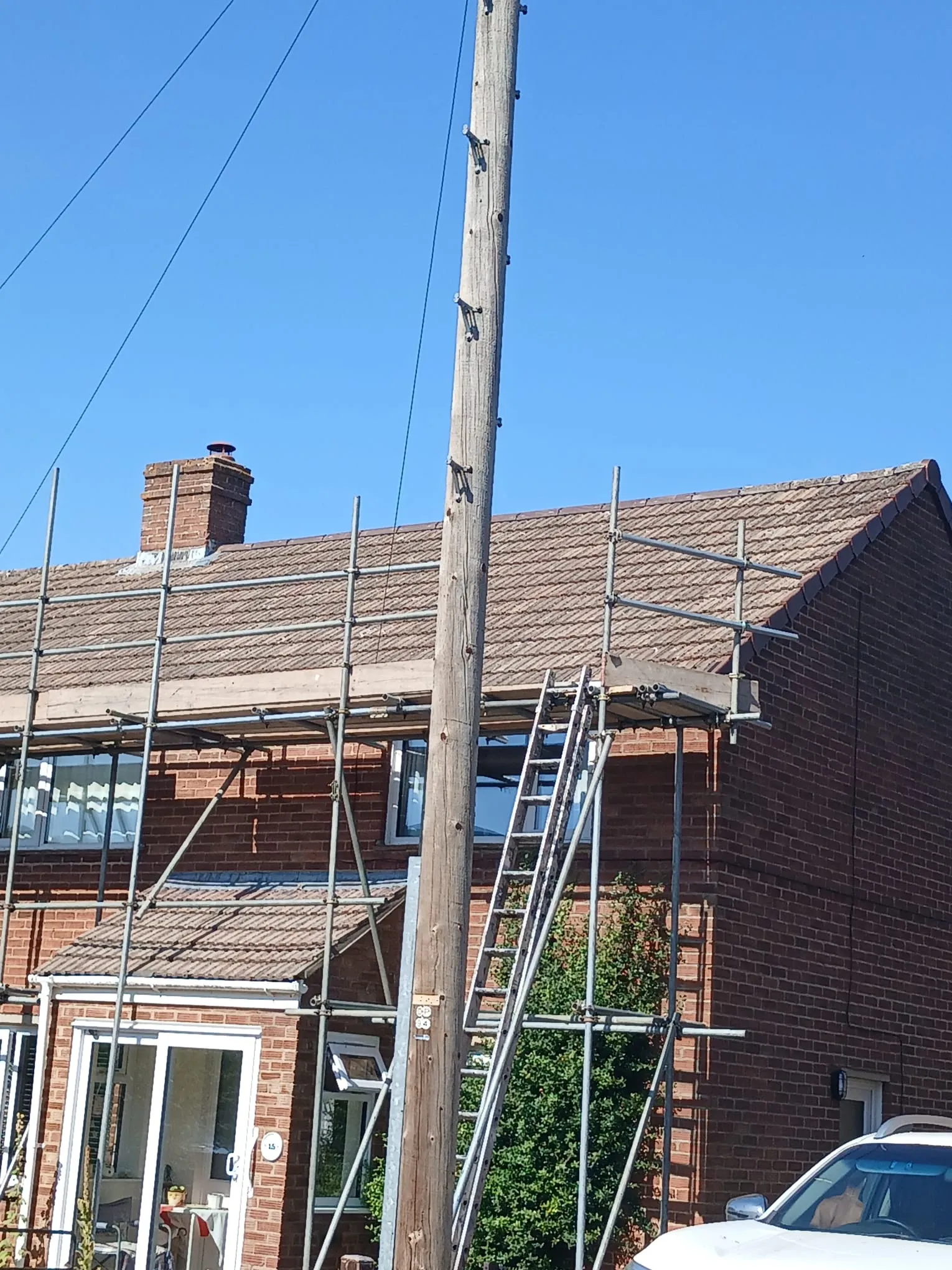 Scaffolding in place on a residential property for tiled roof and chimney maintenance