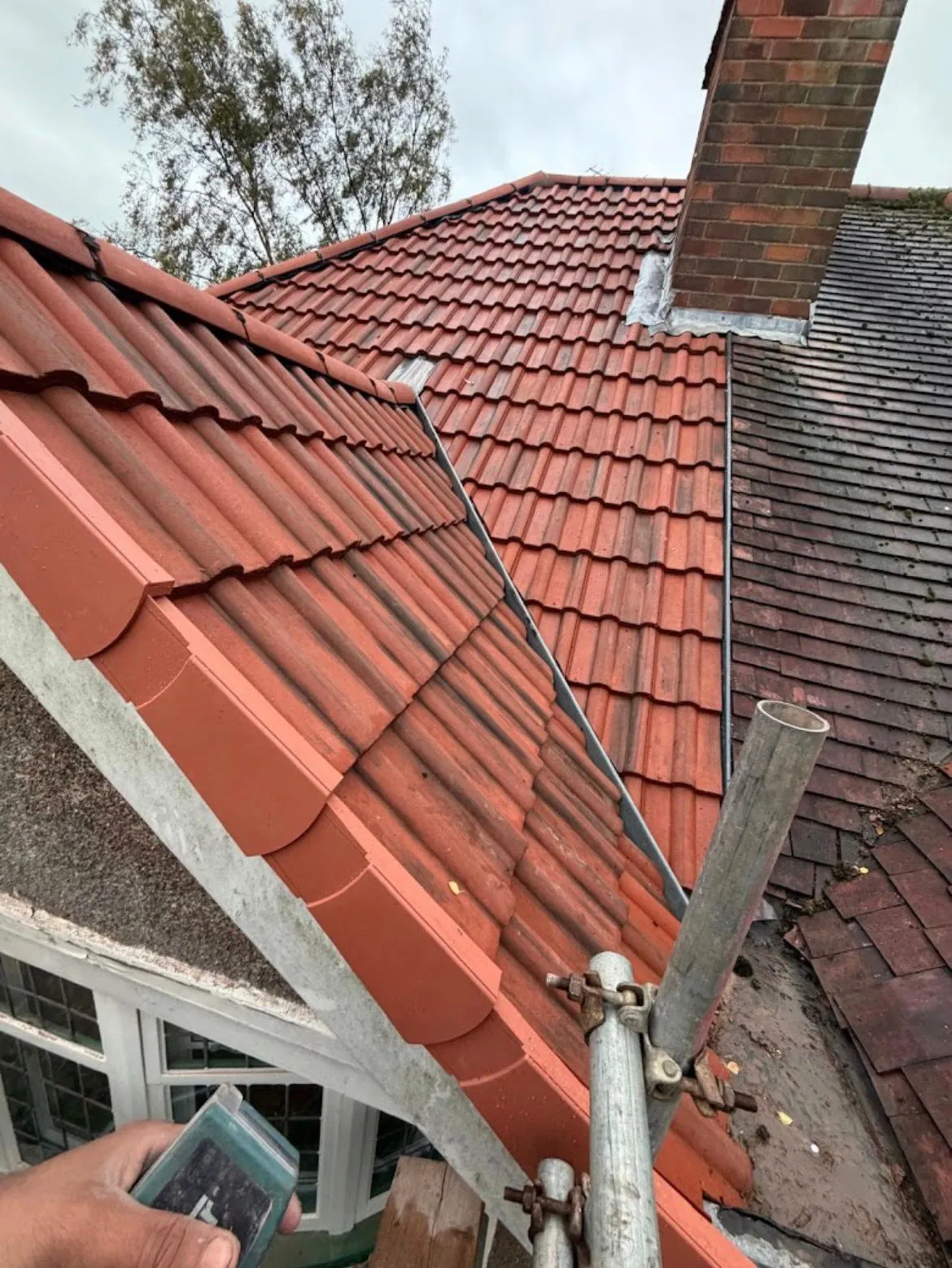 Pitched roof with red interlocking tiles, dry verge system, and lead valley flashing