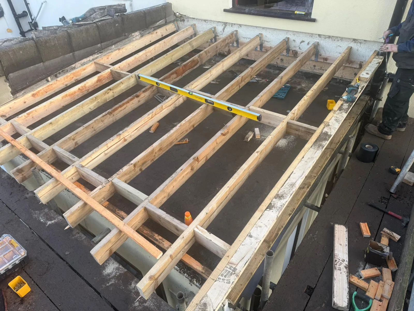 A picture showing the structural wooden joists of a flat roof extension under construction by P D Roofing & Building Contractors.