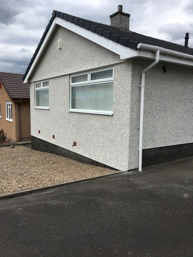 A house in Lanark with white roughcasting and a grey tiled roof