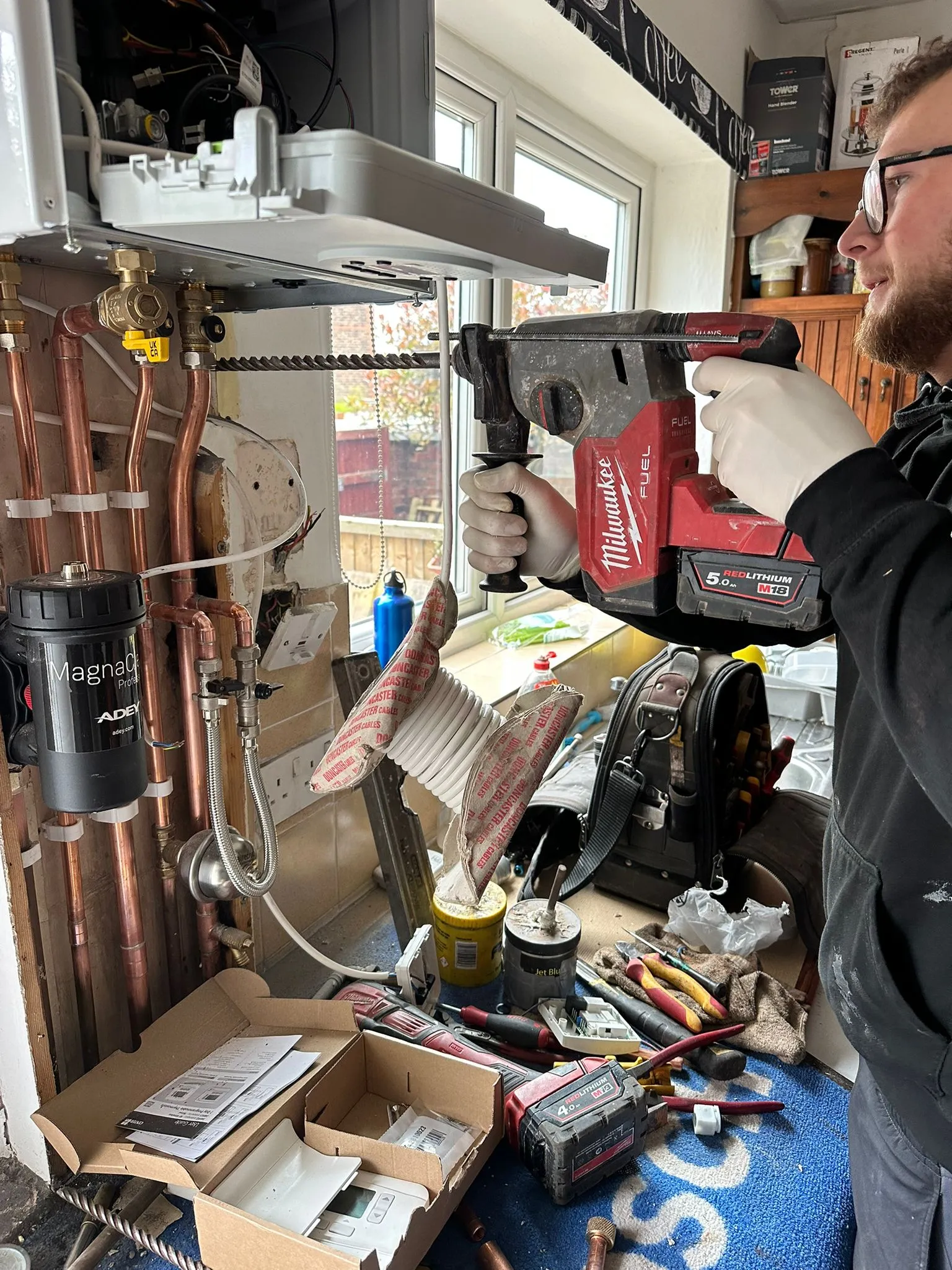 A Redorr Heating & Cooling Services Ltd engineer installing a new boiler in a residential property in Warrington.