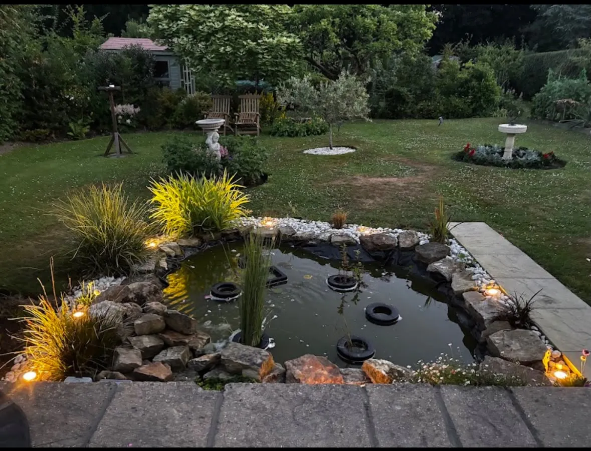 Outdoor garden pond lighting and illuminated rockery installed in a residential garden