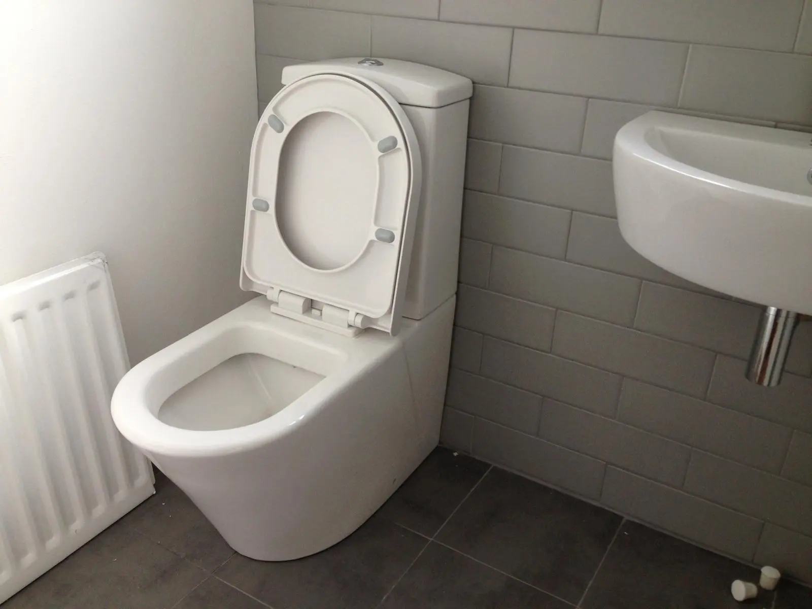 Modern bathroom plumbing installation in Bolton featuring a new toilet and sink