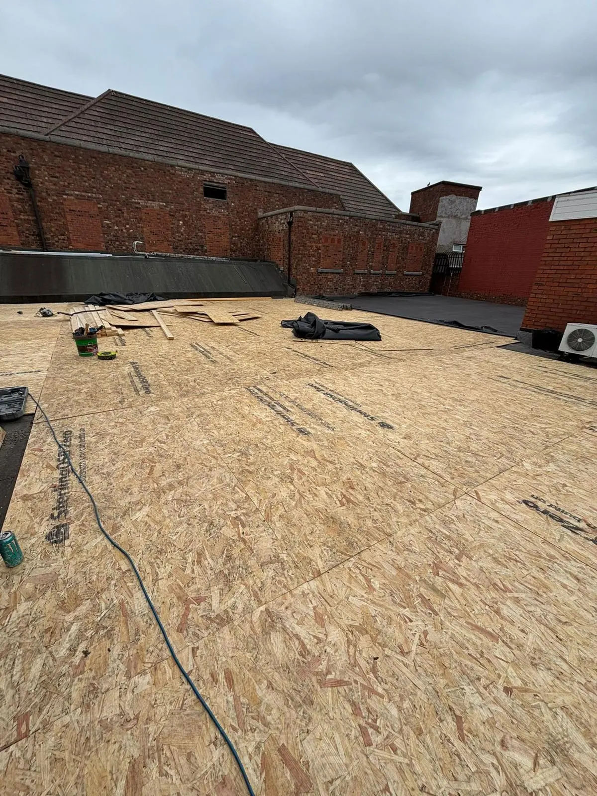 New timber OSB decking being installed for a flat roof replacement by Premium Roofing Contractors