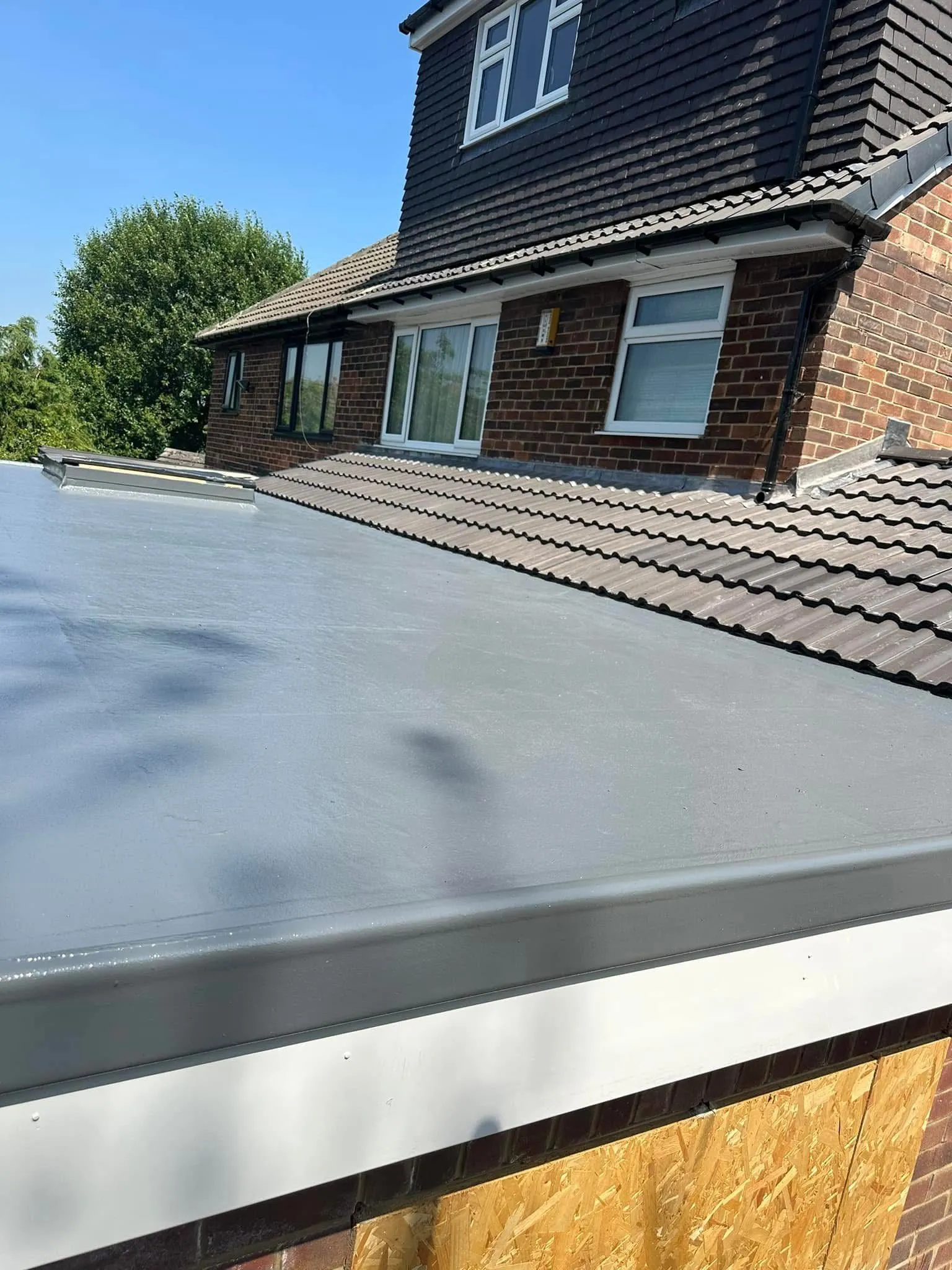 New grey GRP flat roof installation on a house extension by Renovation Roofing Ltd.