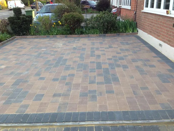 A modern block paved driveway in brown and grey tones, recently installed in front of a residential property.
