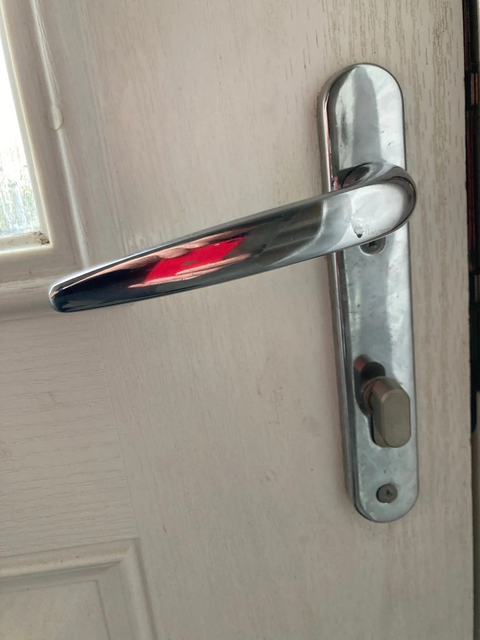 Close-up of a uPVC door handle and euro cylinder lock, showing typical components that may need repair or an upgrade.