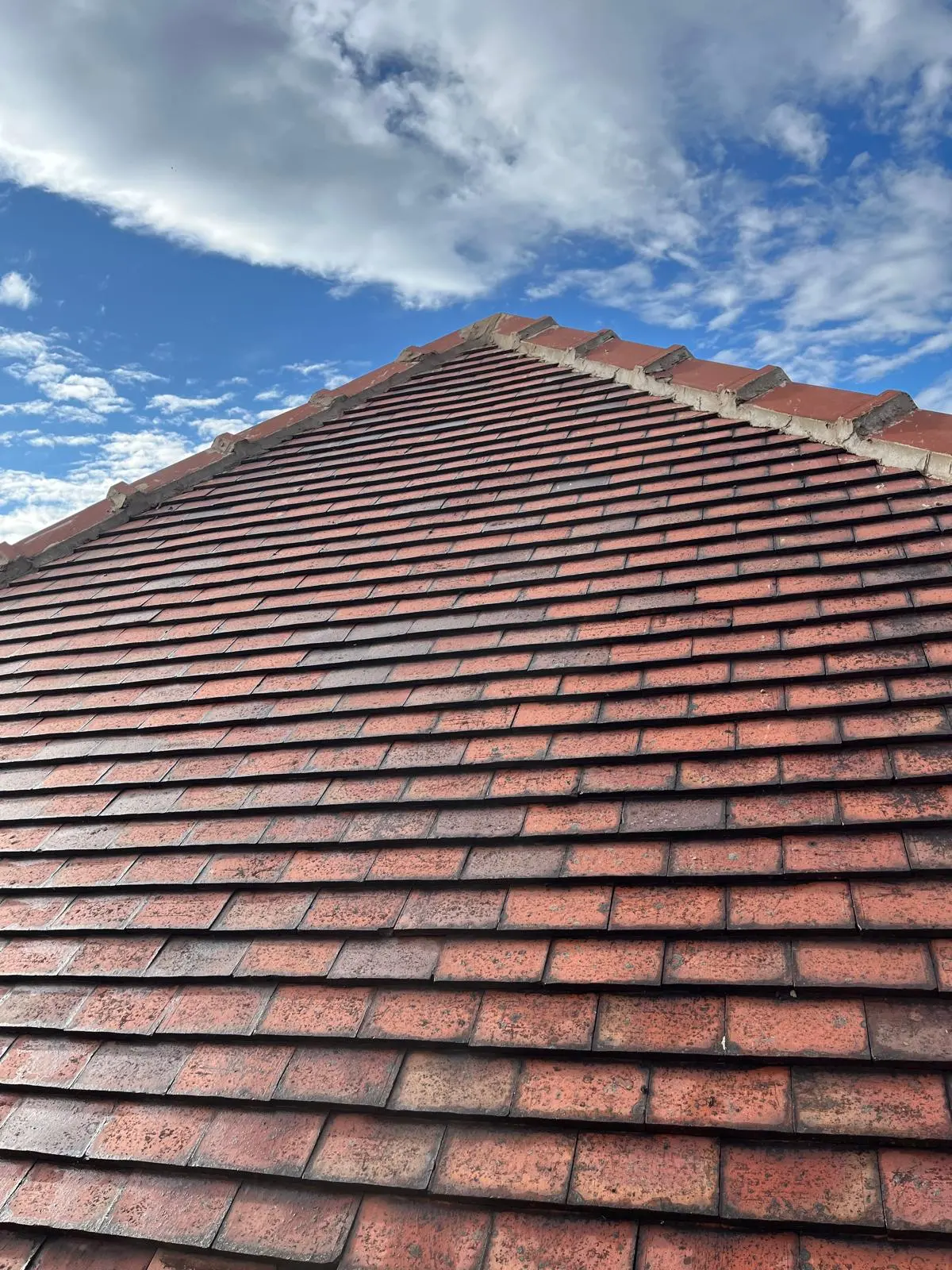 Traditional red clay tile roofing on a pitched residential property