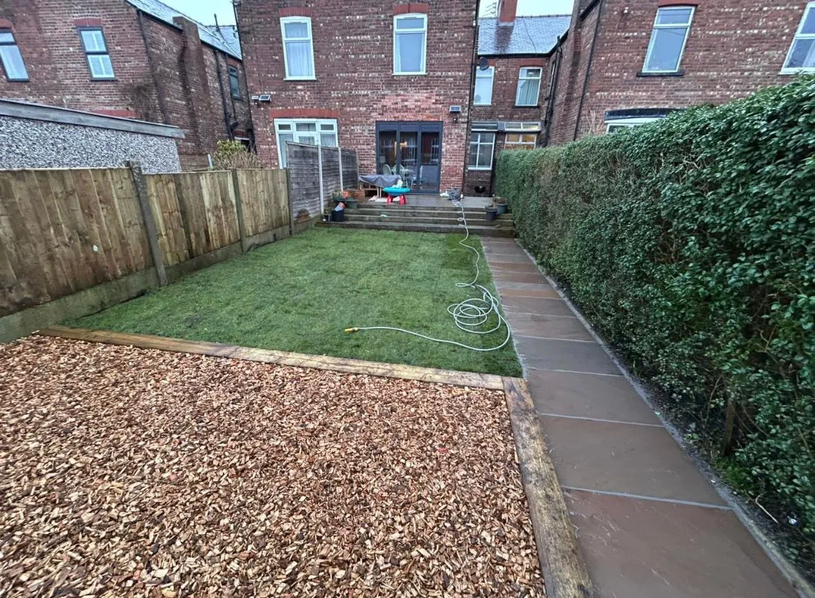 A landscaped garden with a new lawn, paved path, and timber sleeper borders in Essex