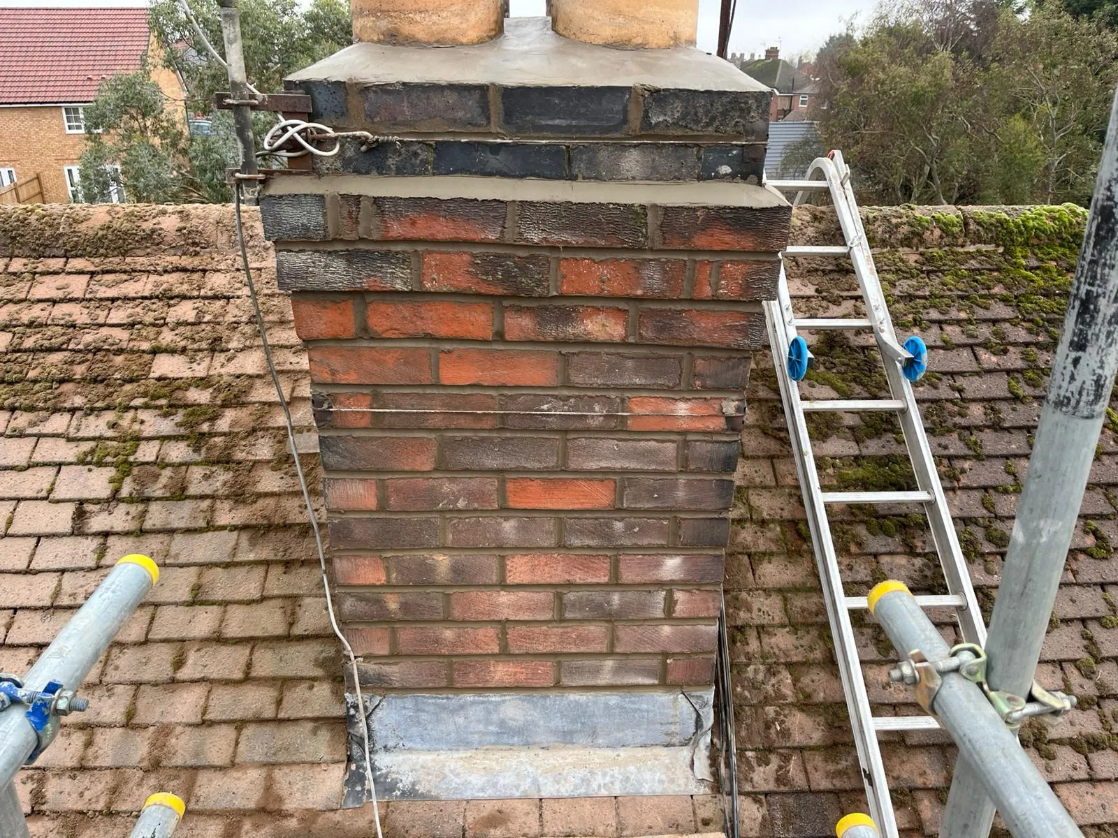 Recently repointed brick chimney on a residential roof in Gloucestershire