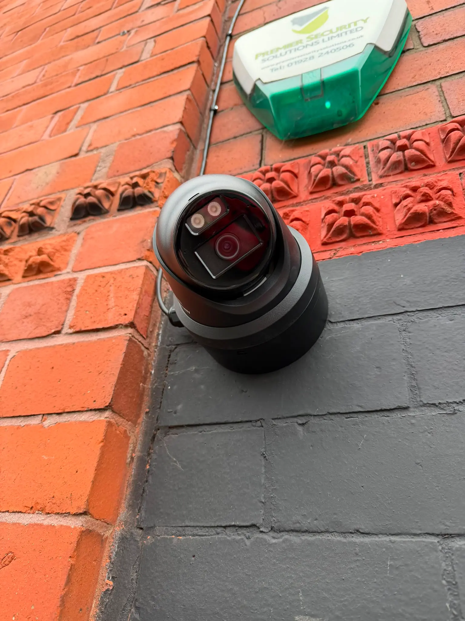 Weatherproof outdoor double socket and switch installation on a red brick wall