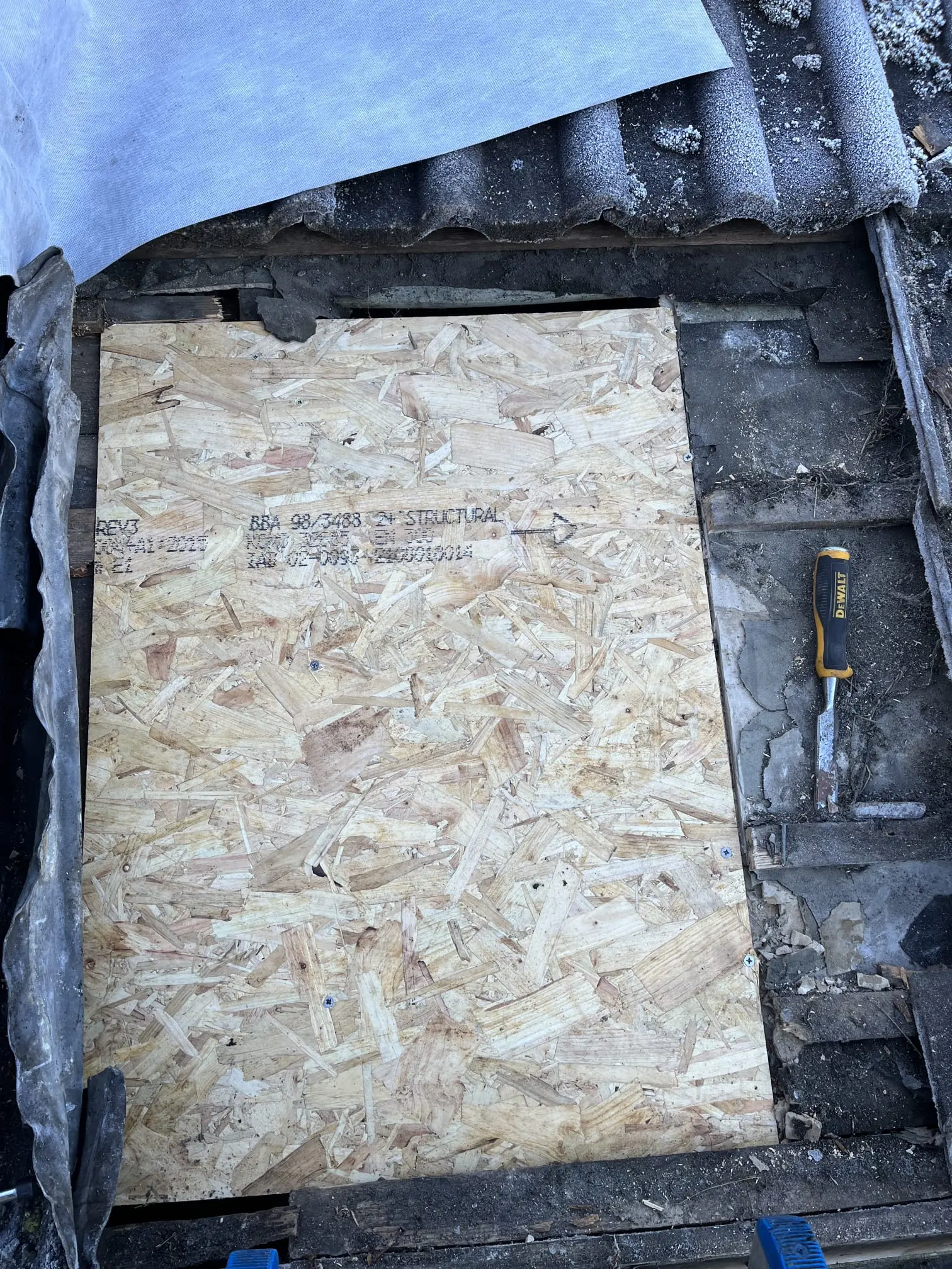 Close-up of structural roof repairs showing new OSB timber boarding being installed to fix a damaged roof section