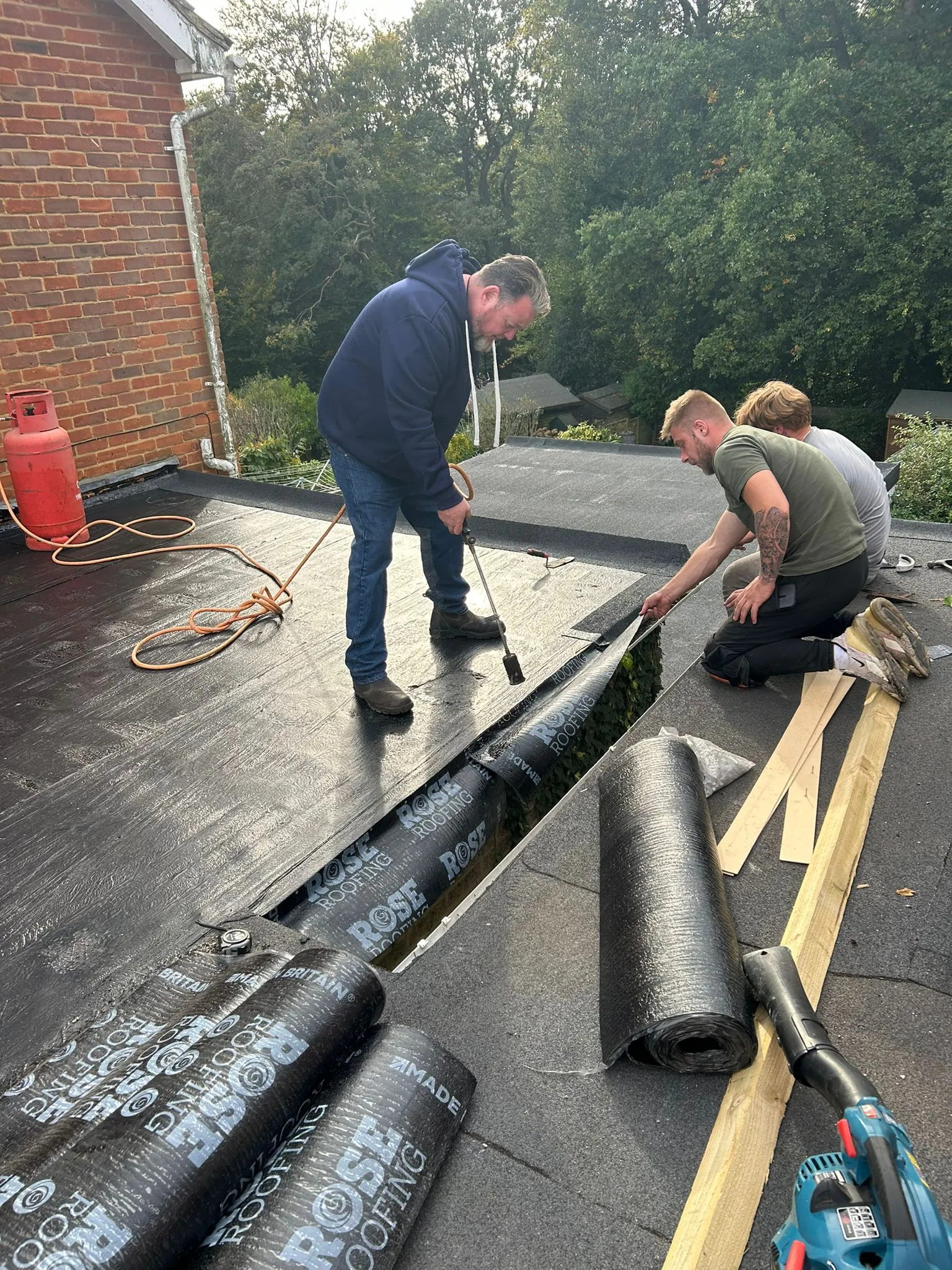 Local roofers installing a new felt flat roof using a torch-on system in Cornwall.