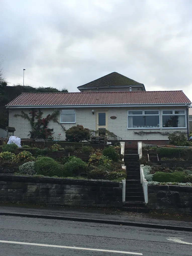 A bungalow with a red tile roof and tiered garden in Lanark, showcasing professional roofing work