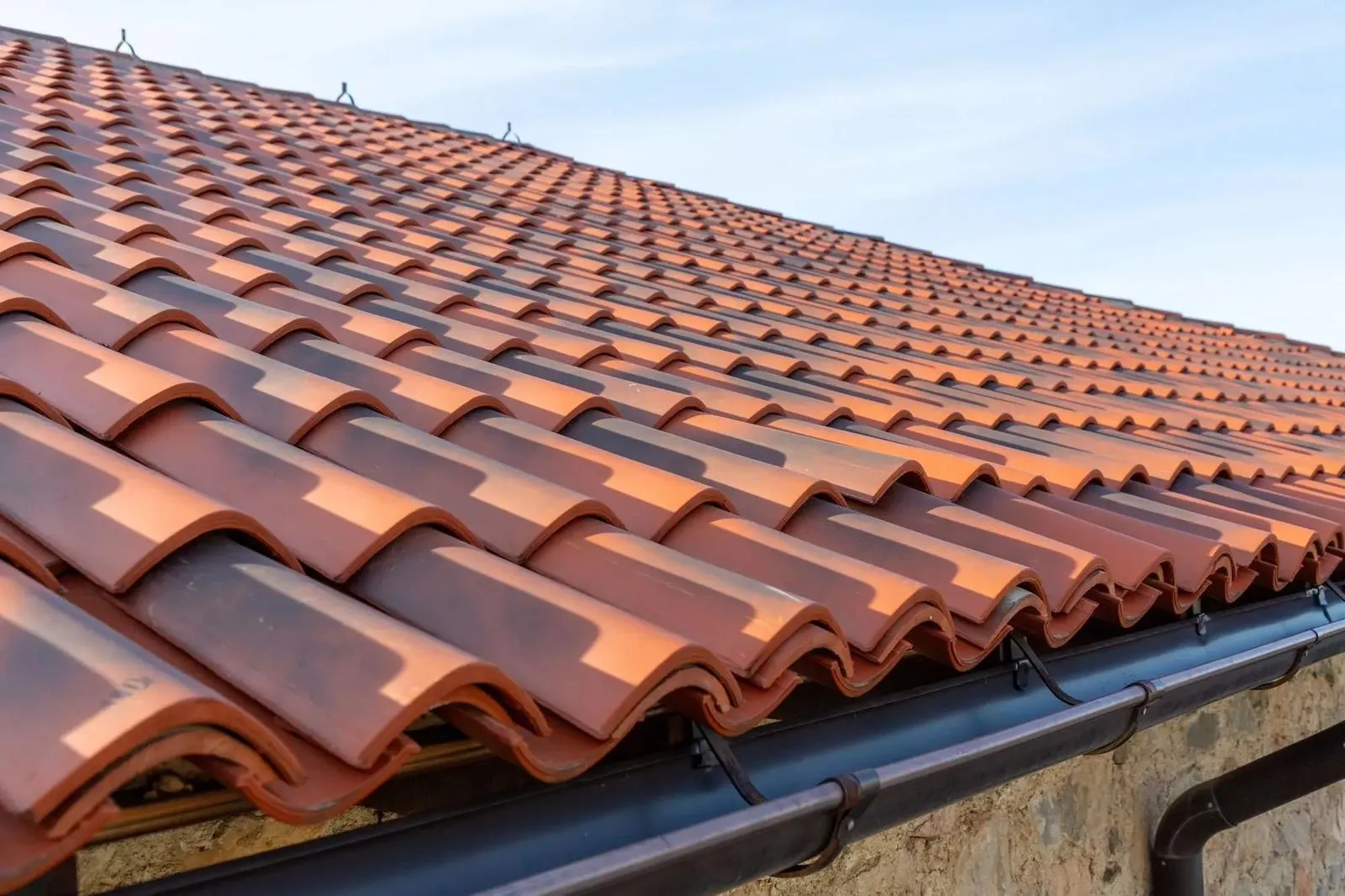 Newly installed red roof tiles and black guttering by Better Choice Roofing & Cleaning.