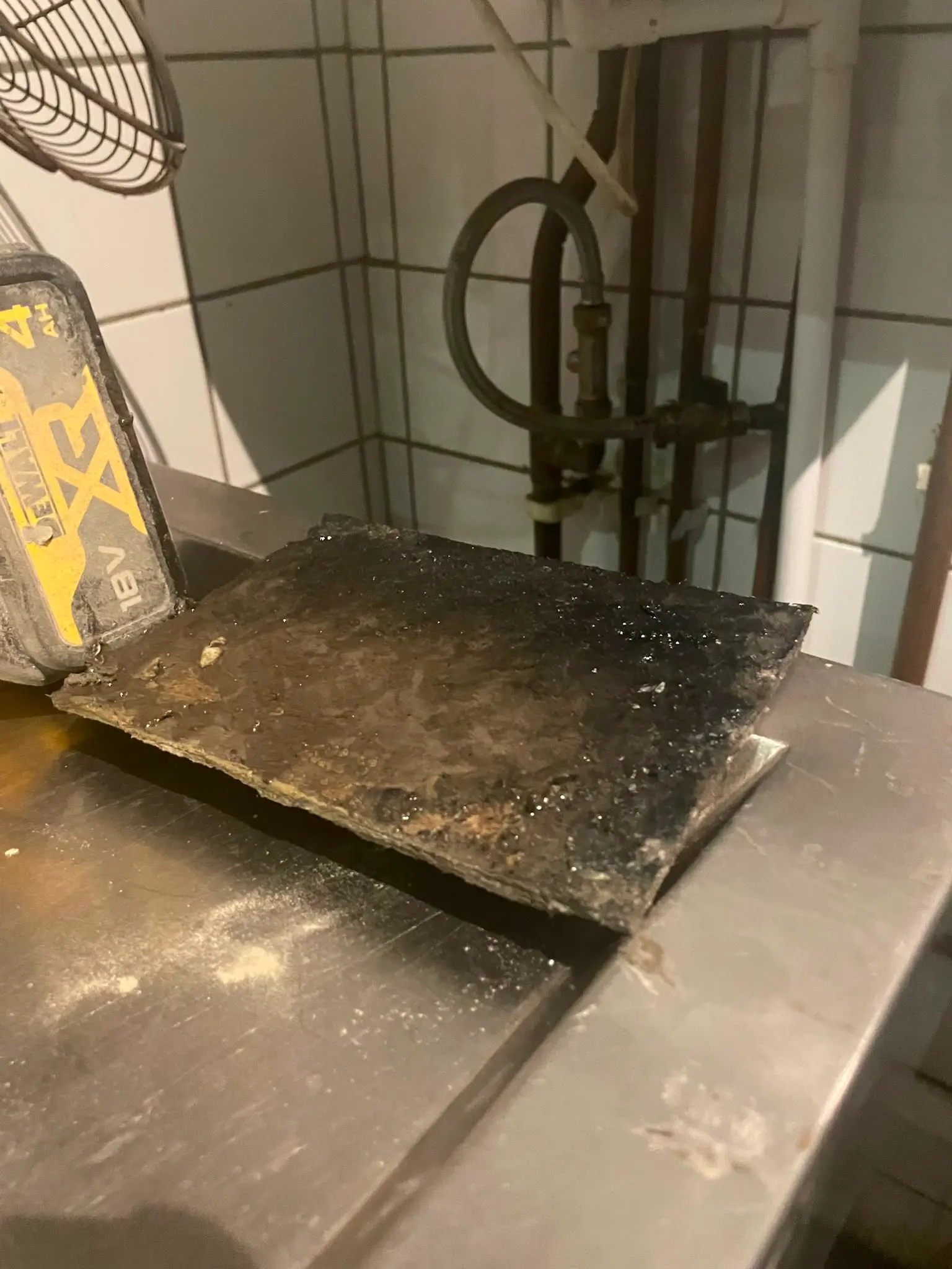 Solidified fat, oil, and grease blockage removed during commercial drain cleaning