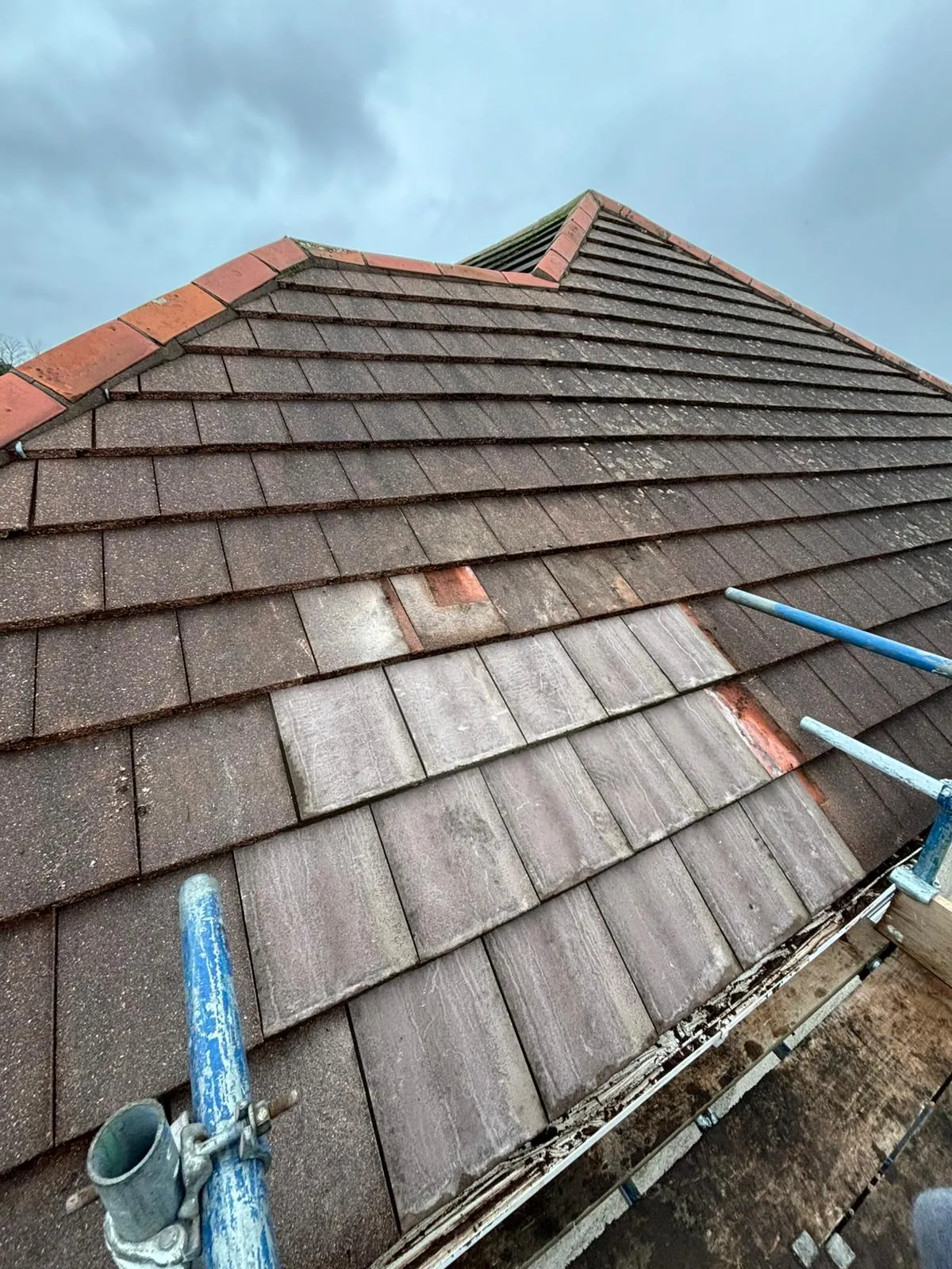 Tiled roof repair work in progress with scaffolding