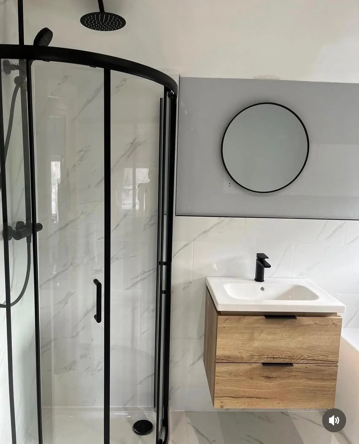 Modern bathroom installation in York featuring a black-trimmed shower and wooden vanity unit.