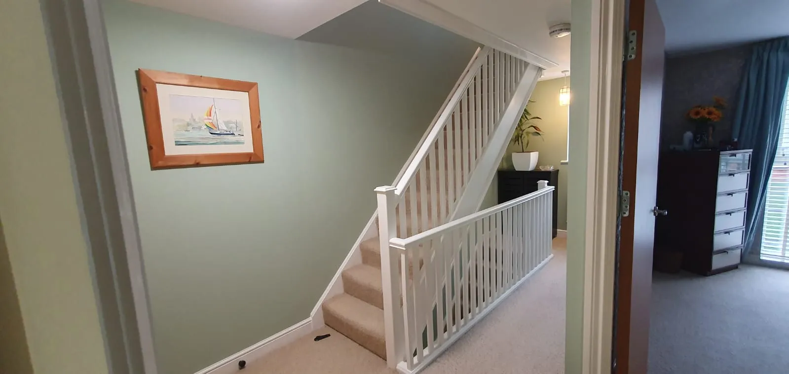 Professionally painted interior hallway with sage green walls and white bannisters by FLEX PROPERTY SERVICES in Felixstowe.