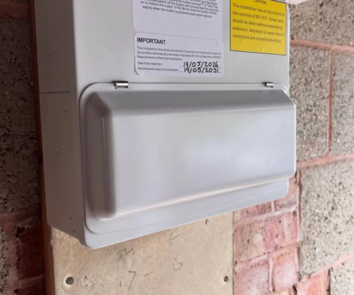 Modern metal-clad consumer unit replacement installed with BS 7671 compliance labels