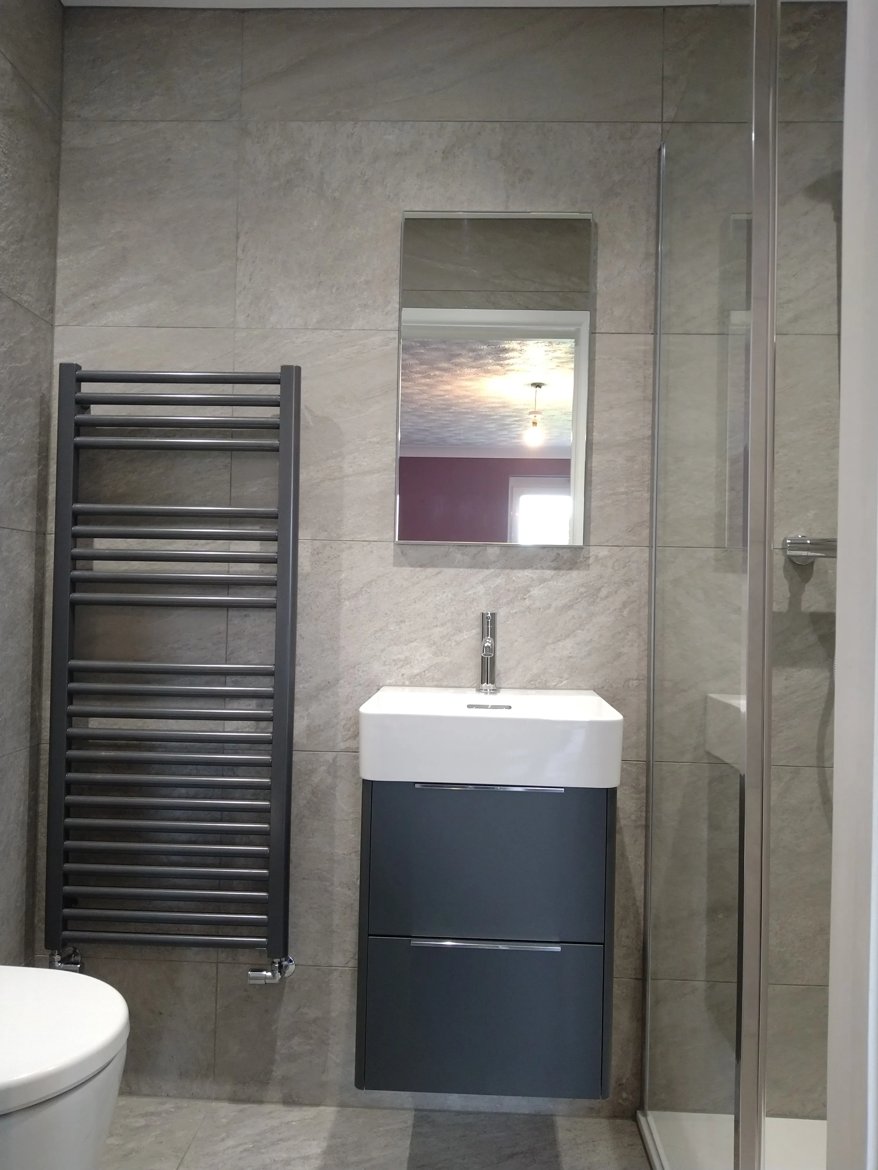 Bespoke luxury bathroom installation in Plymouth by Sands & Vossen, featuring modern grey porcelain tiling and a high-end walk-in shower.