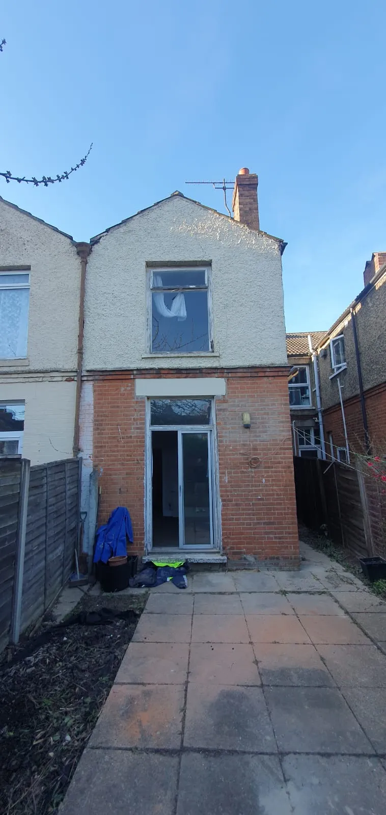 Rear view of a house with a patio and sliding doors, showcasing property maintenance services in Suffolk.