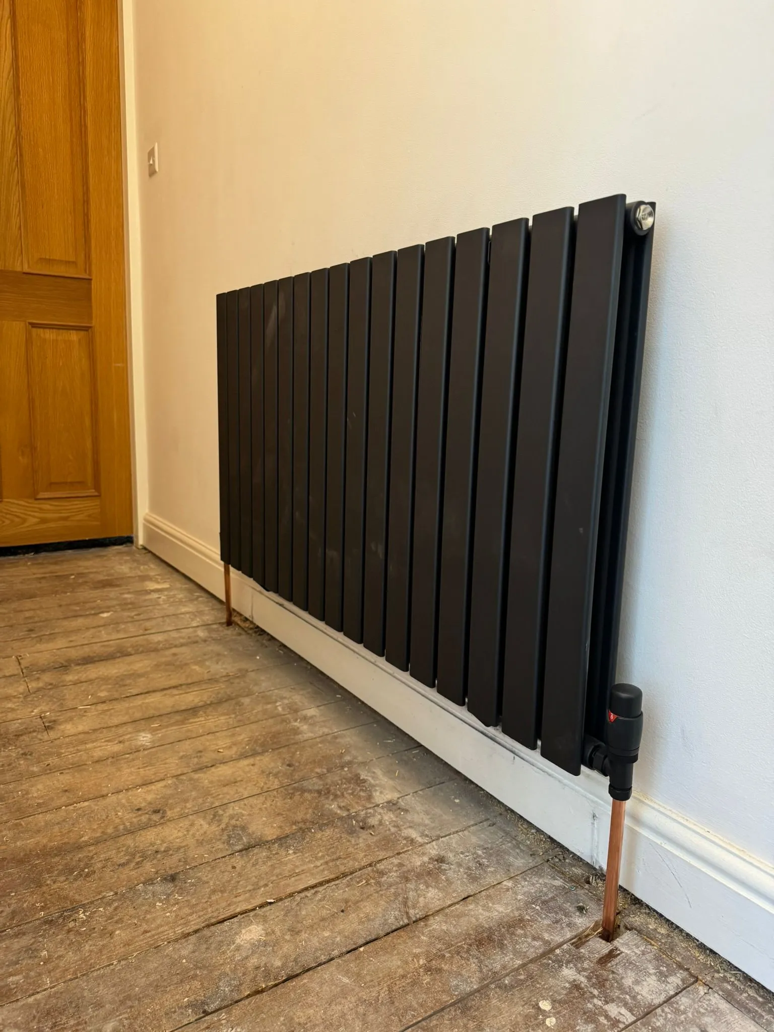 Modern black designer radiator installation by Redorr Heating & Cooling Services Ltd in Warrington.