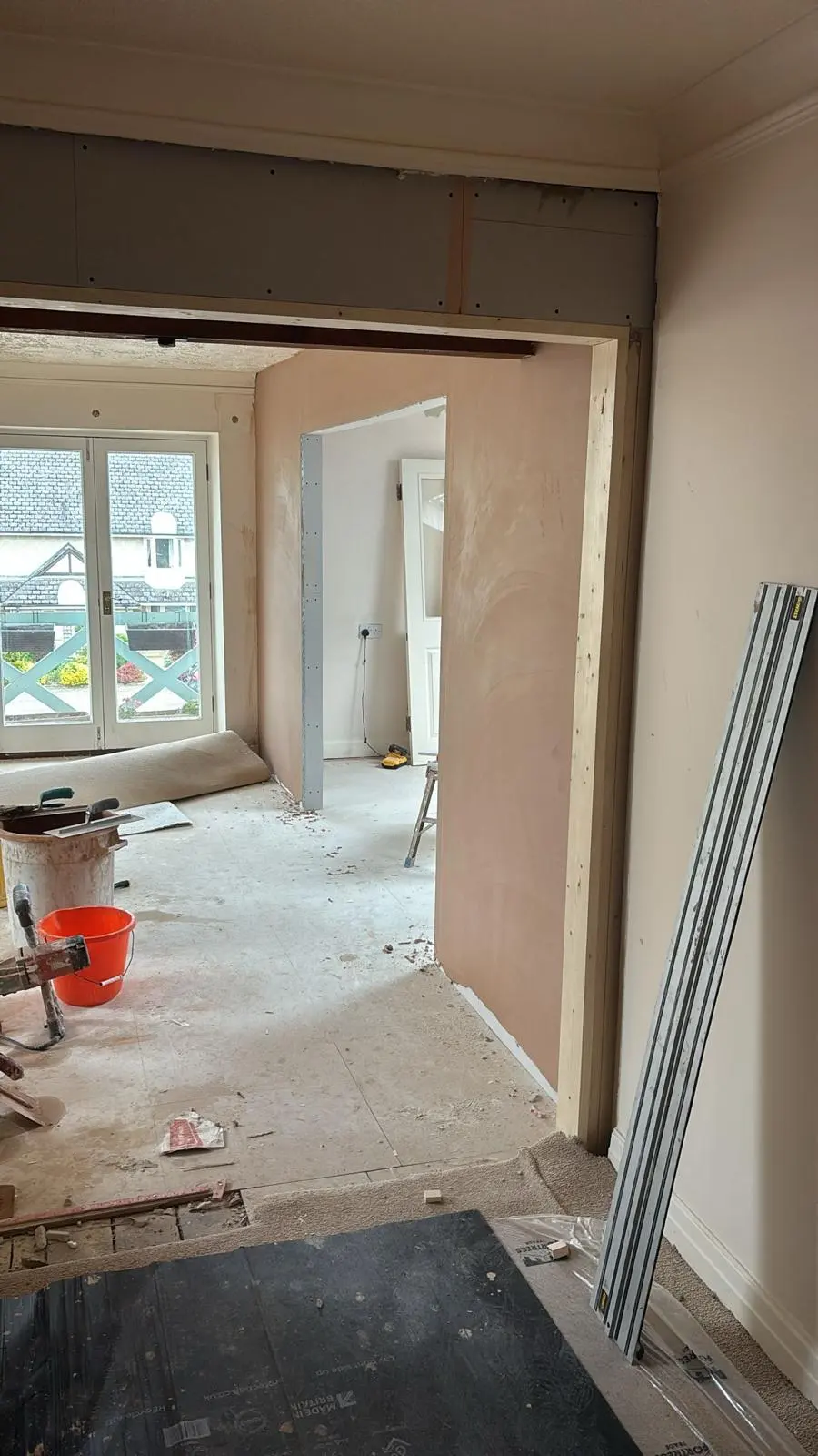 Expert spatial planning and structural reconfiguration underway in a Tetbury property, creating a seamless open-plan layout with freshly plastered walls.