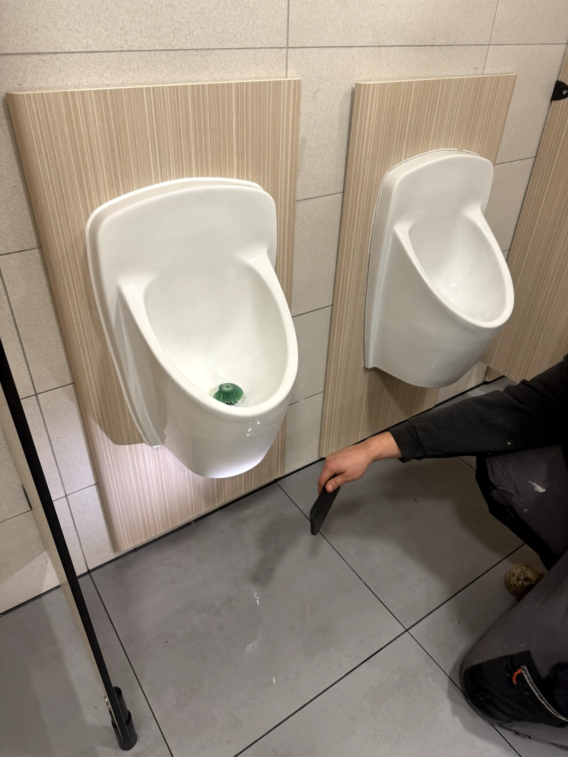 Professional plumber performing commercial plumbing maintenance on urinals in Darwen.