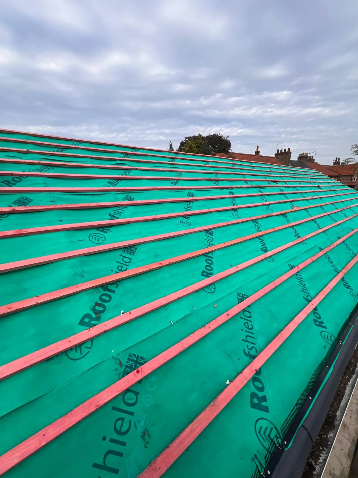 Pitched roof construction with green waterproof membrane and wooden battens