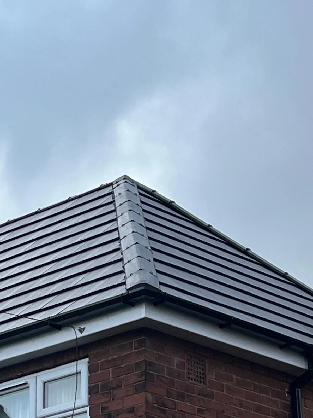 Modern concrete tile roofing installation on a pitched roof with clean white uPVC fascias