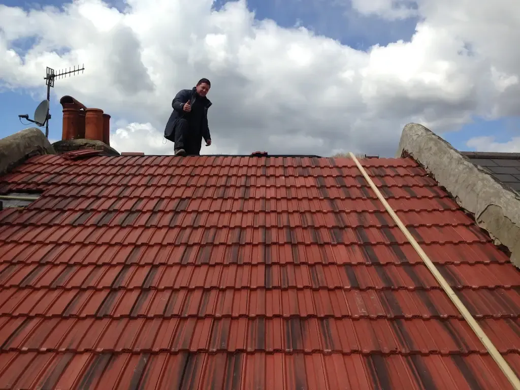 A professional roofer from Elite Paving and Roofing LTD giving a thumbs-up on a red tiled roof, signifying quality work on a roofing project in Canterbury, Kent.