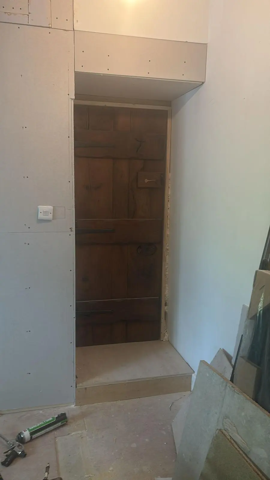 Traditional solid wood door fitted into a new plasterboard stud wall during a heritage building restoration and spatial reconfiguration project.
