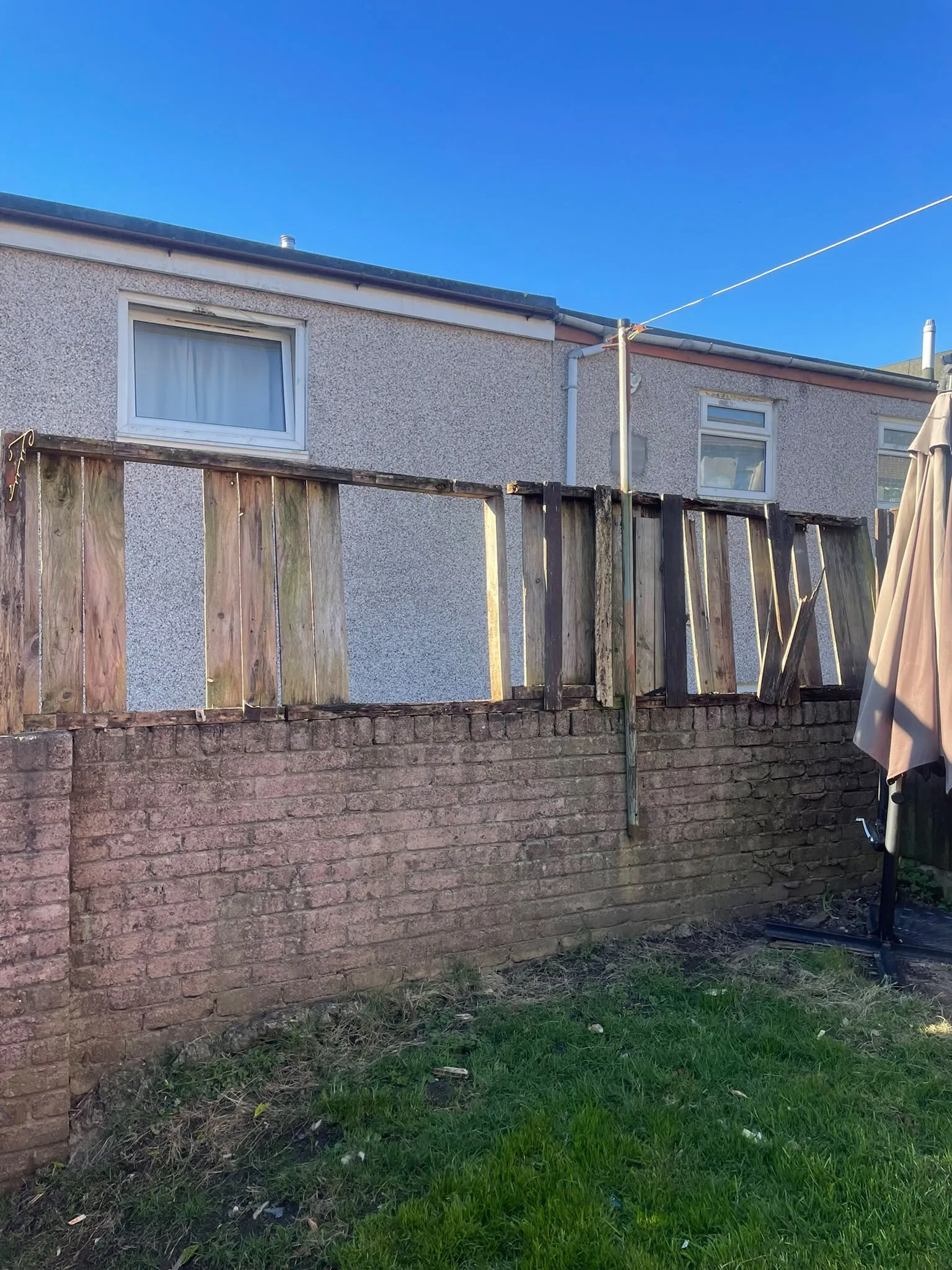 Damaged garden fence panel with broken timber slats needing repair in South Wales