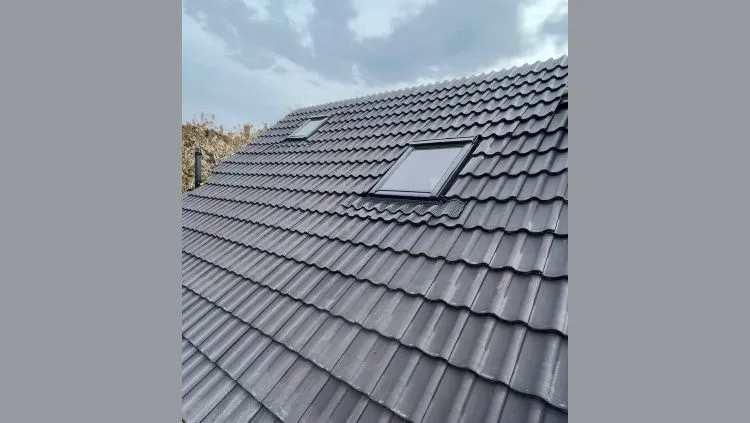 A professional new roof installation with grey tiles and skylights
