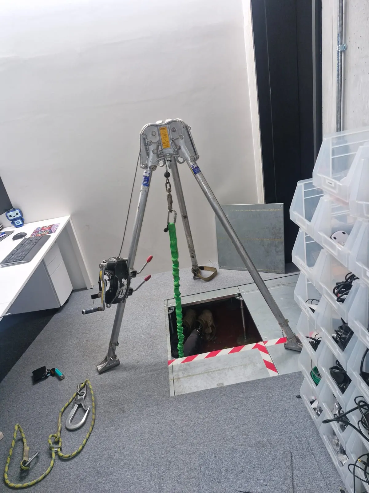 Roberts Drainage Ltd engineer performing a confined space inspection in a commercial building using safety equipment.