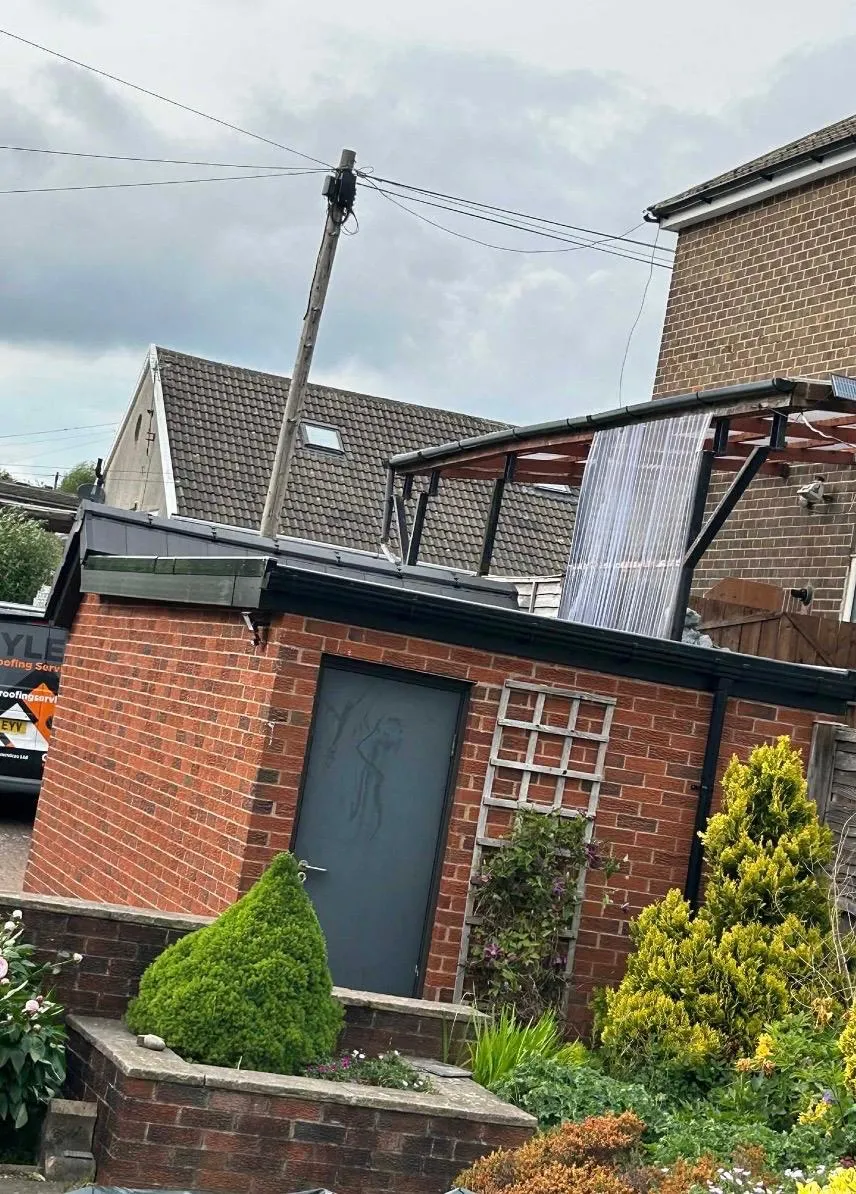 A professional flat roof installation on a brick garage in Holmfirth by Tyler’s Roofing Services.