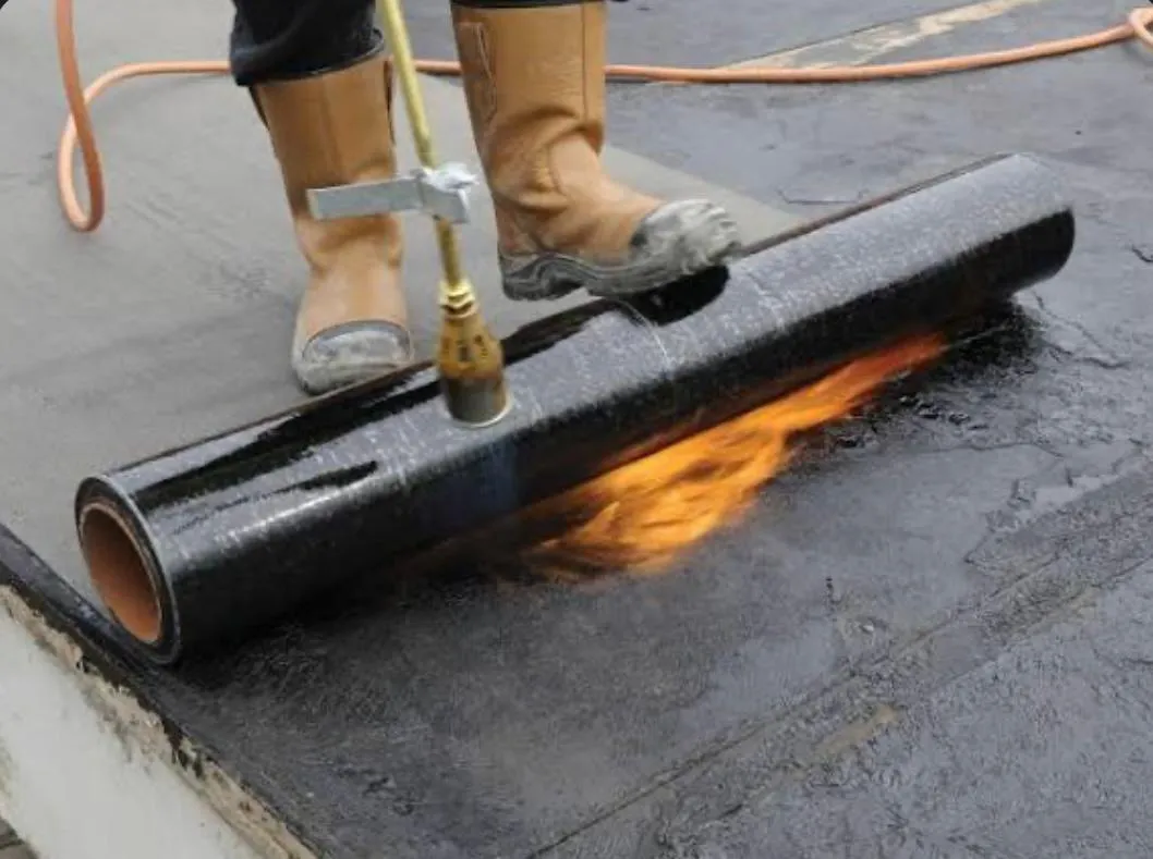 Professional installation of a torch-on felt flat roof system by Sky Top Roofing LTD.