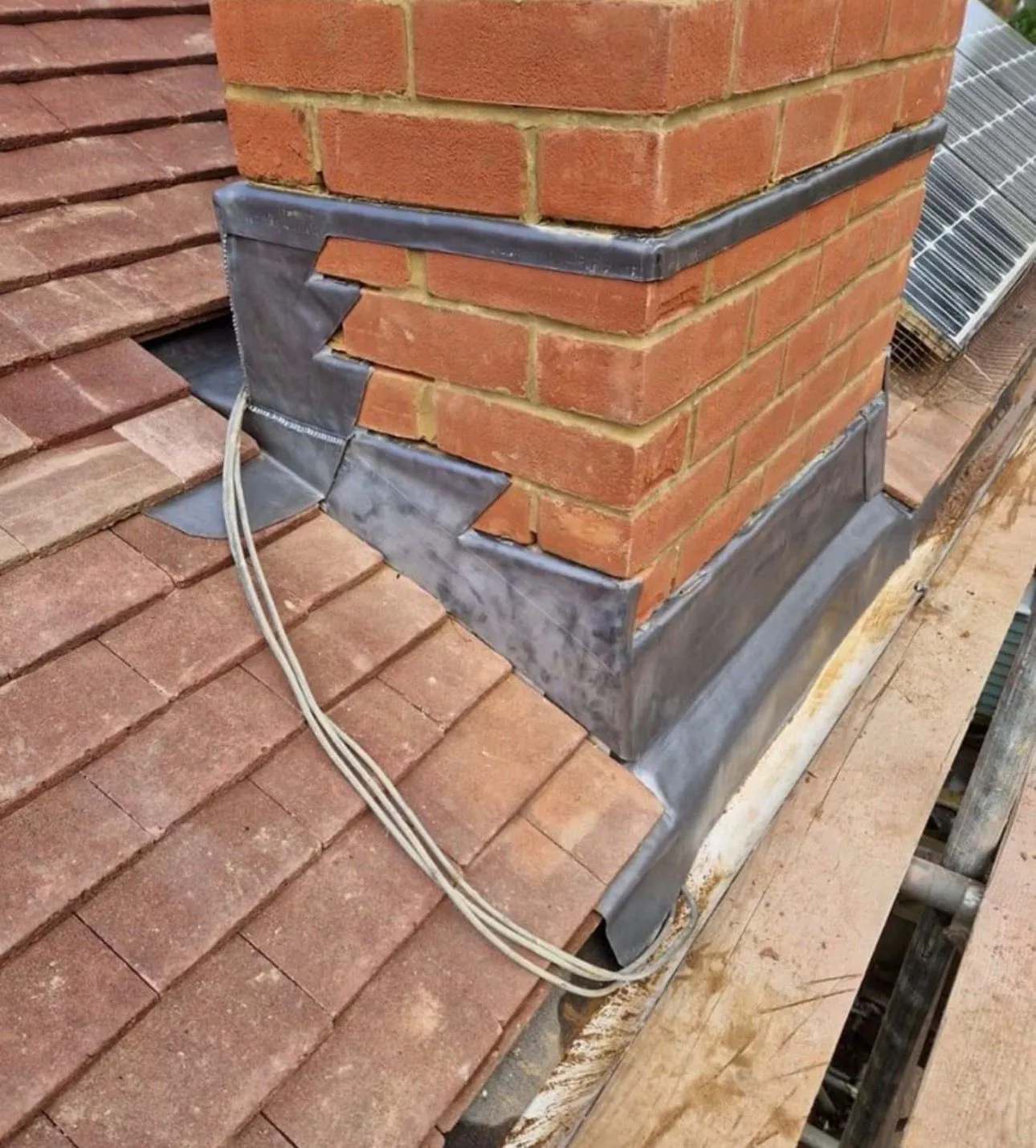 Expert lead work around a chimney on a tiled roof by Century Roofing and Building