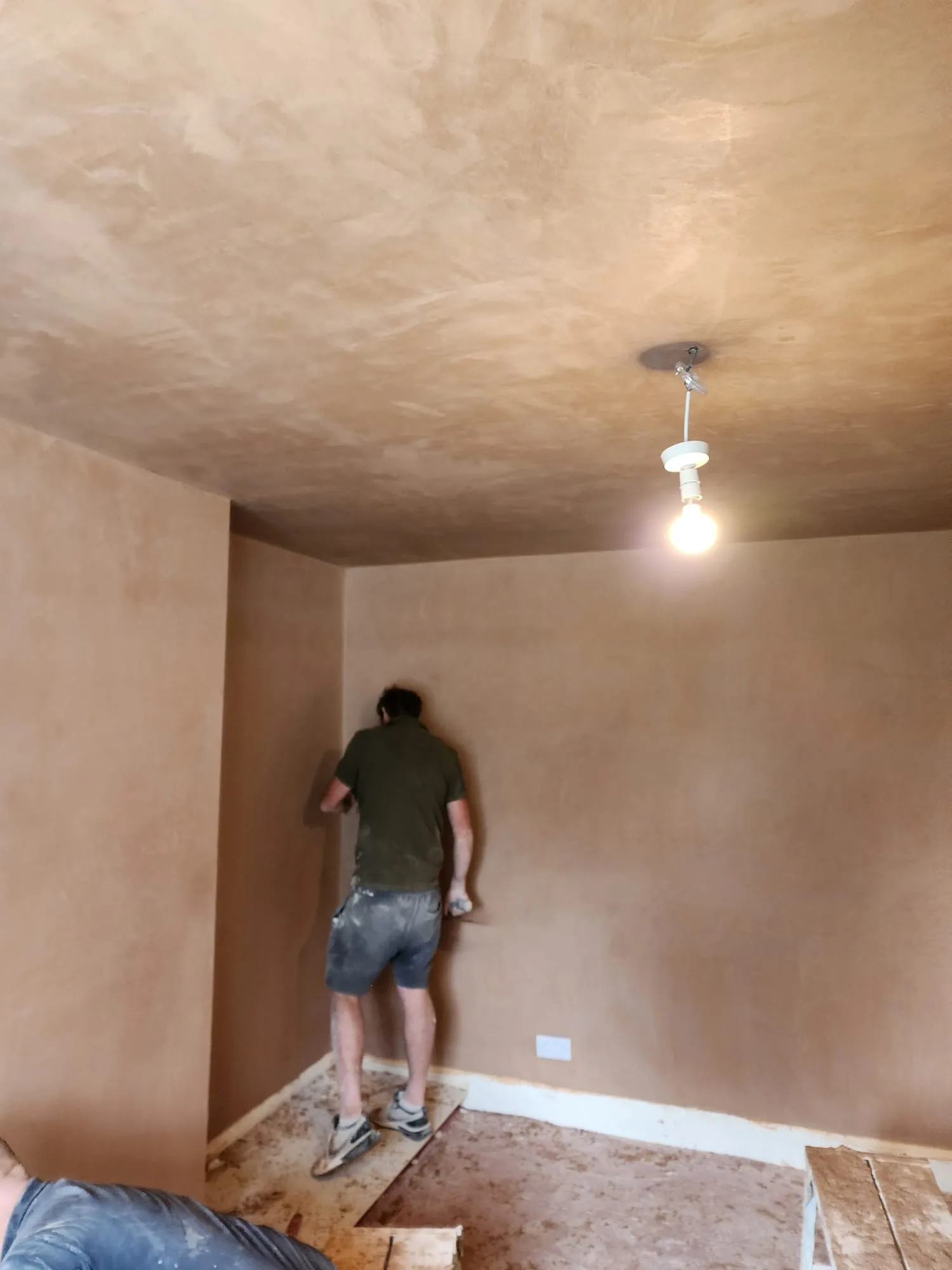 A professional plasterer skimming walls and ceiling in a residential home