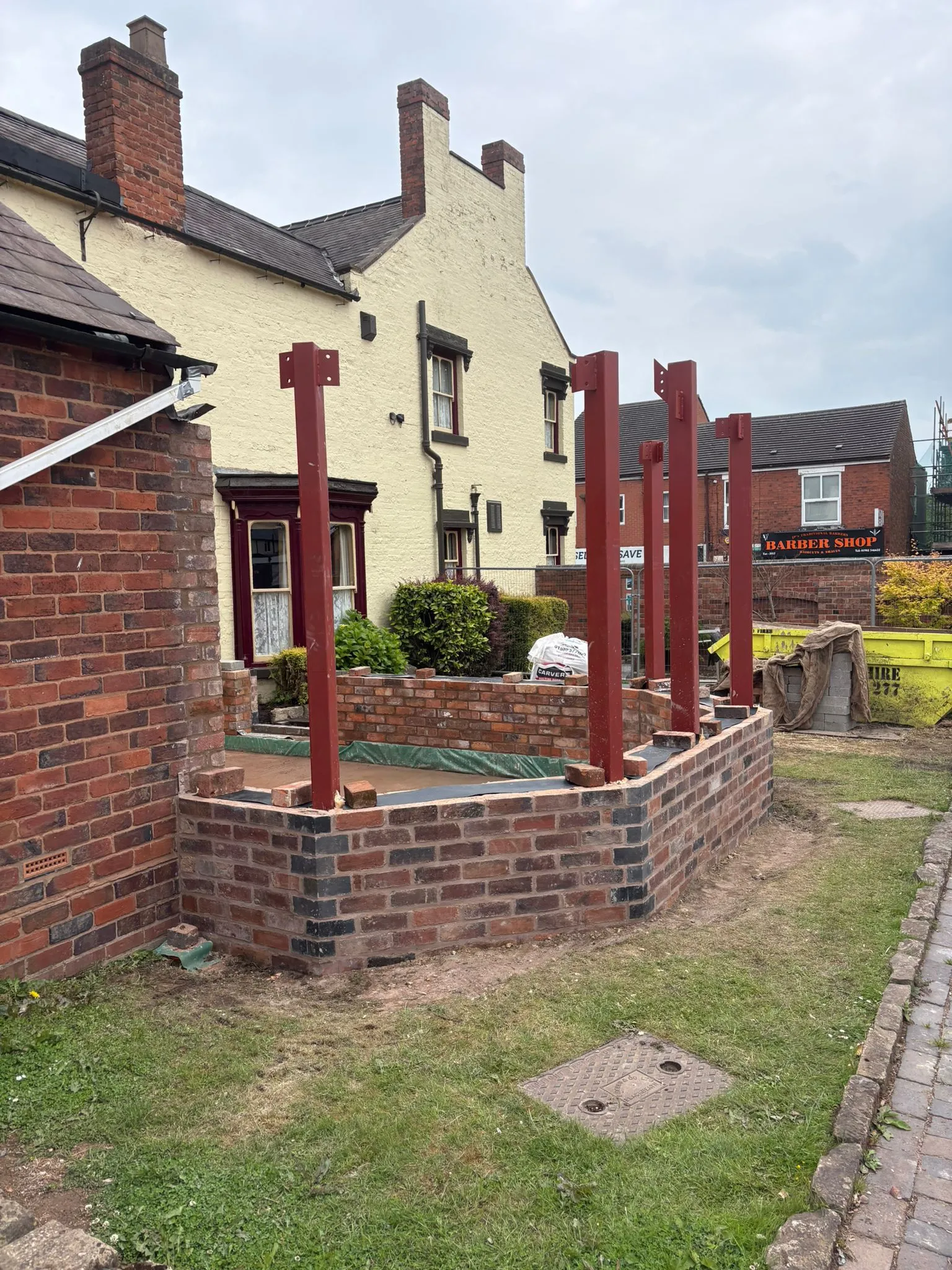 A new home extension taking shape, with brick foundations and structural steelwork visible.