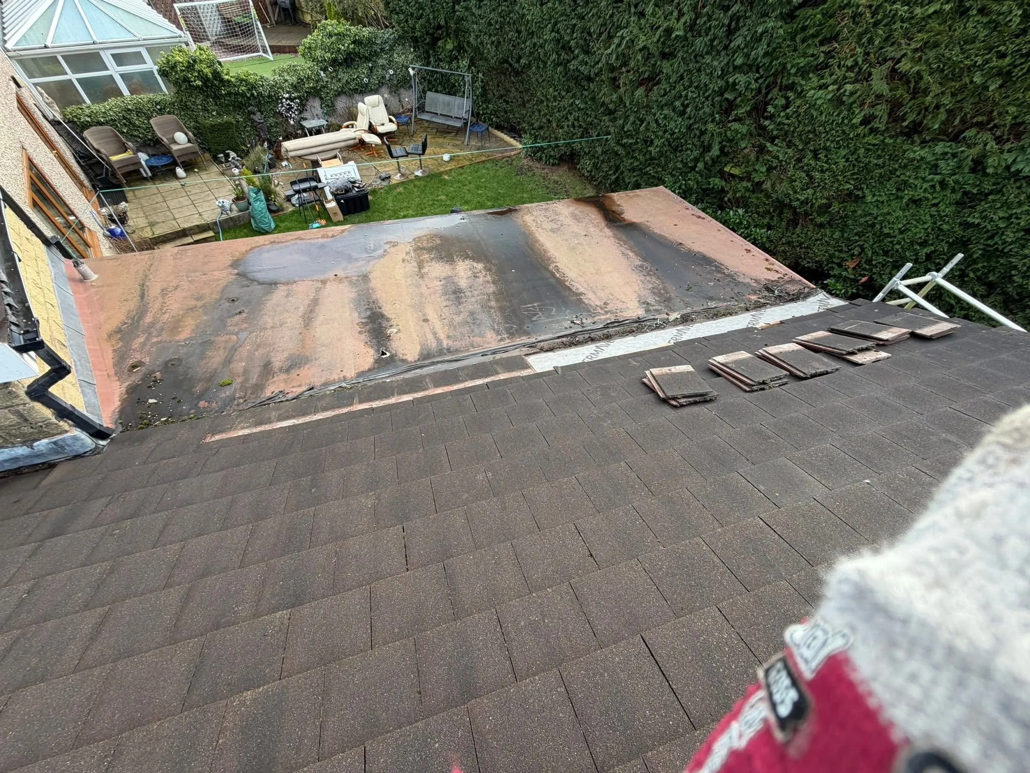 Professional roofing work by Lancashire Roofing Specialist showing a pitched tiled roof and a flat roof replacement in progress.