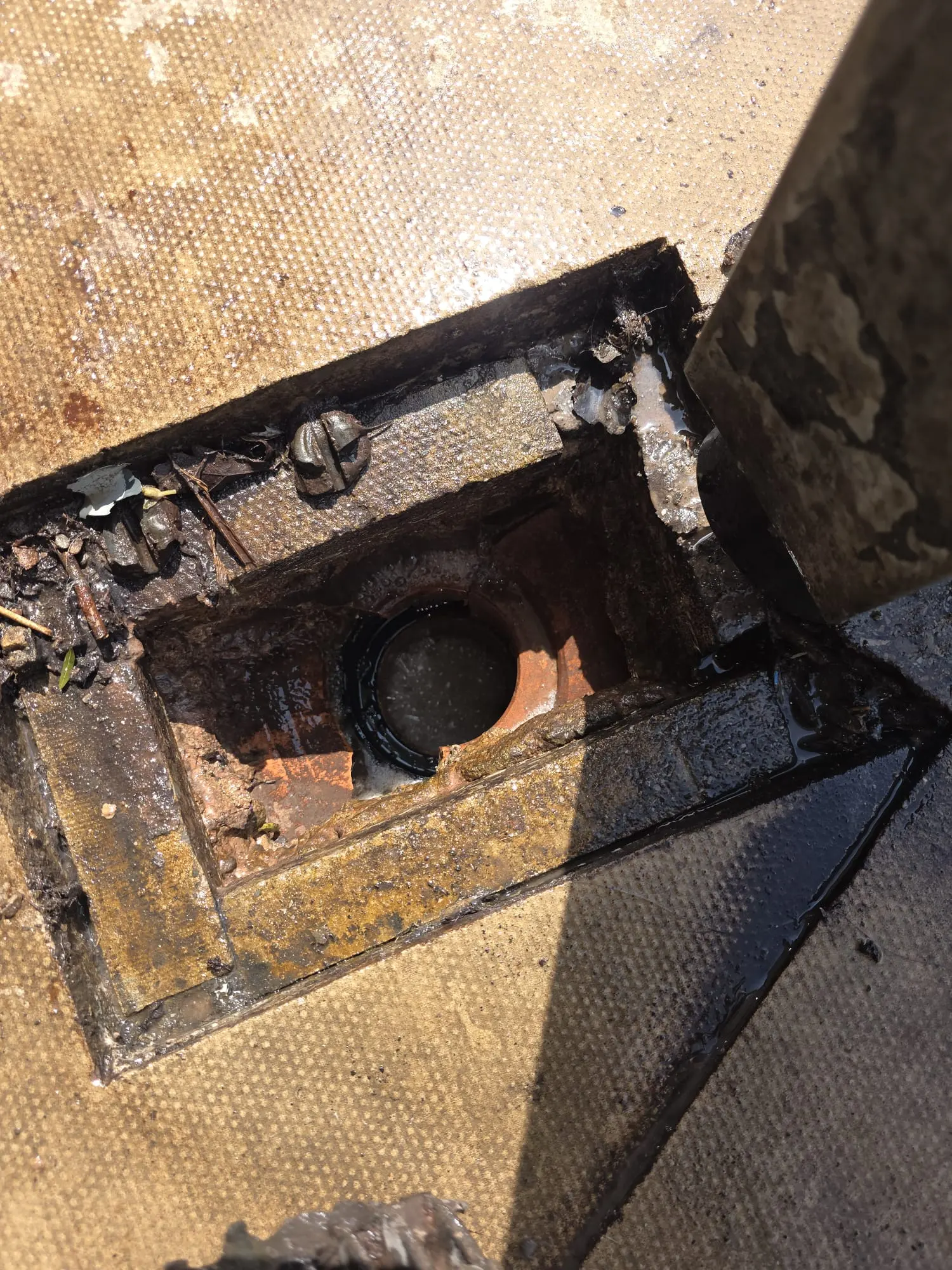 Open outdoor blocked drain gully during inspection.