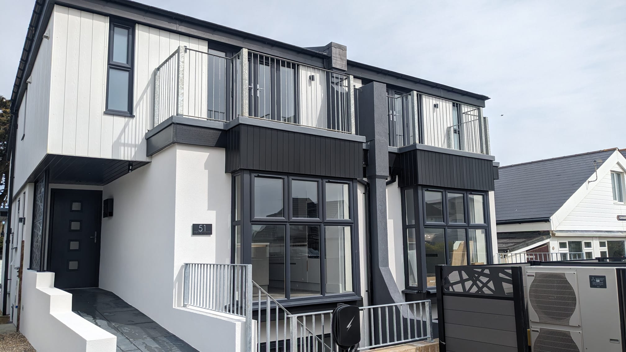 A high-quality finish on a modern home showing professional external rendering in white with contrasting black cladding.