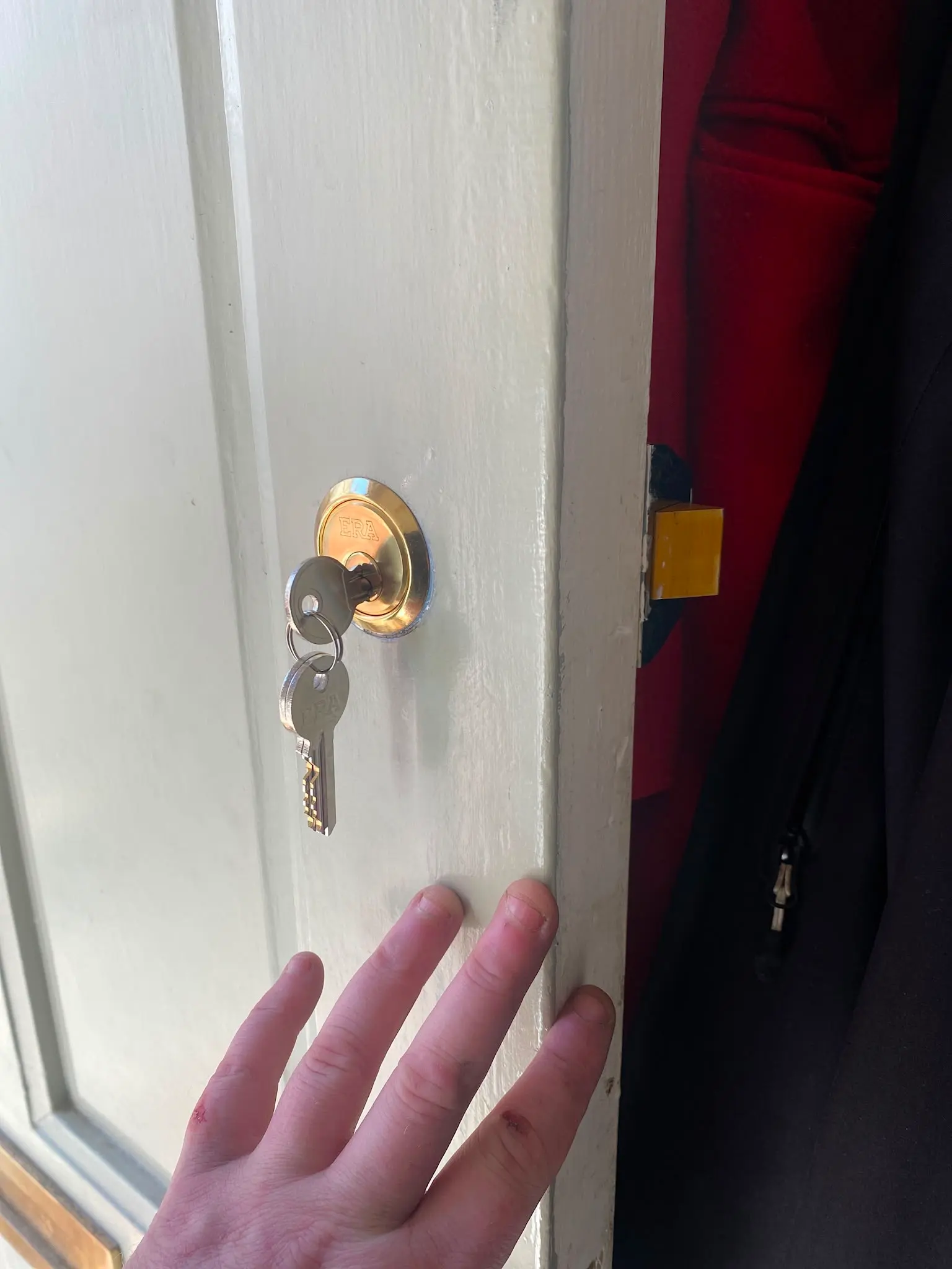Close up of a newly installed brass ERA cylinder lock with keys on a white wooden door by Locksafe York Ltd